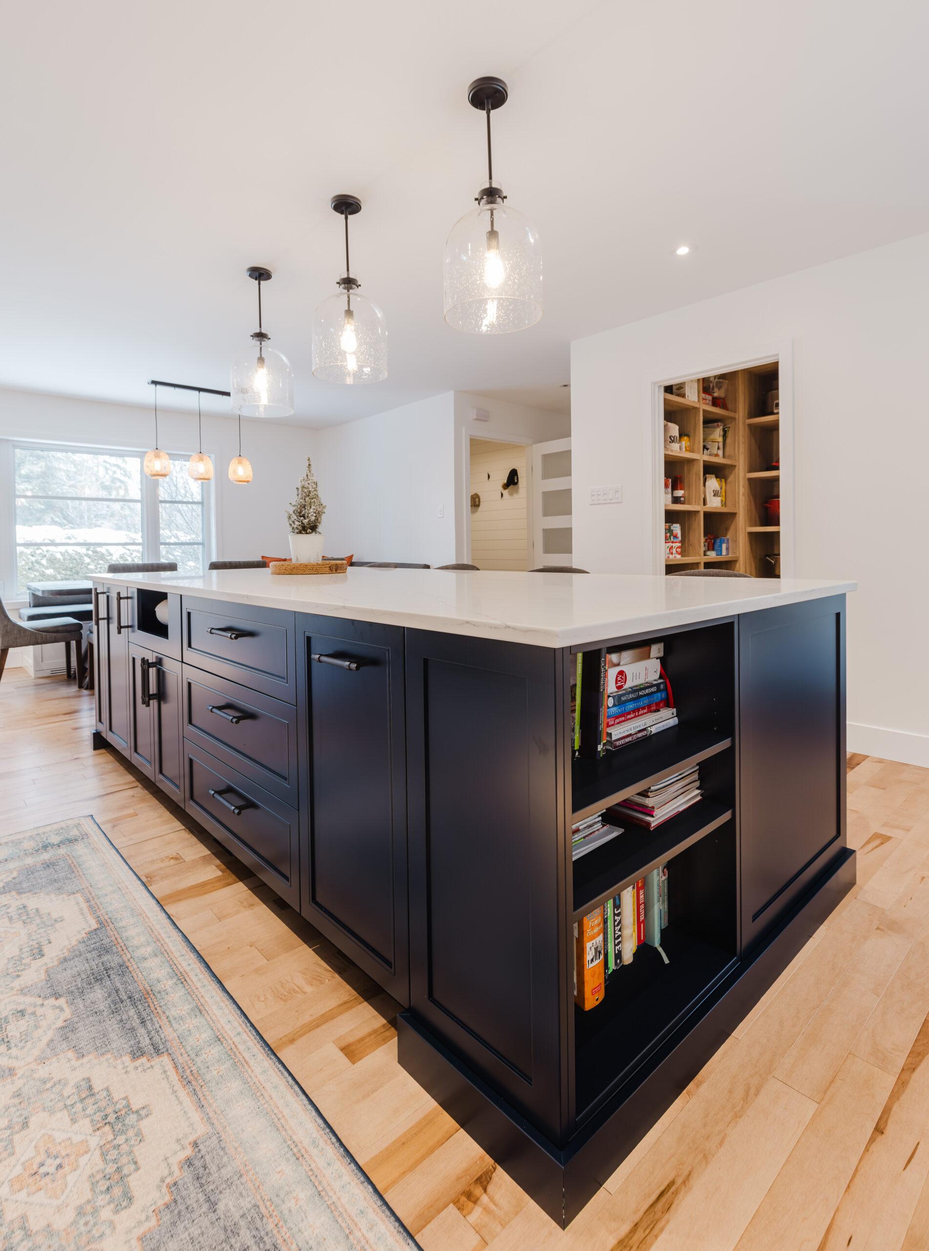 Experience a chic modern kitchen featuring a navy island, elegant white stone countertop, and inviting dining area for seamless gatherings.