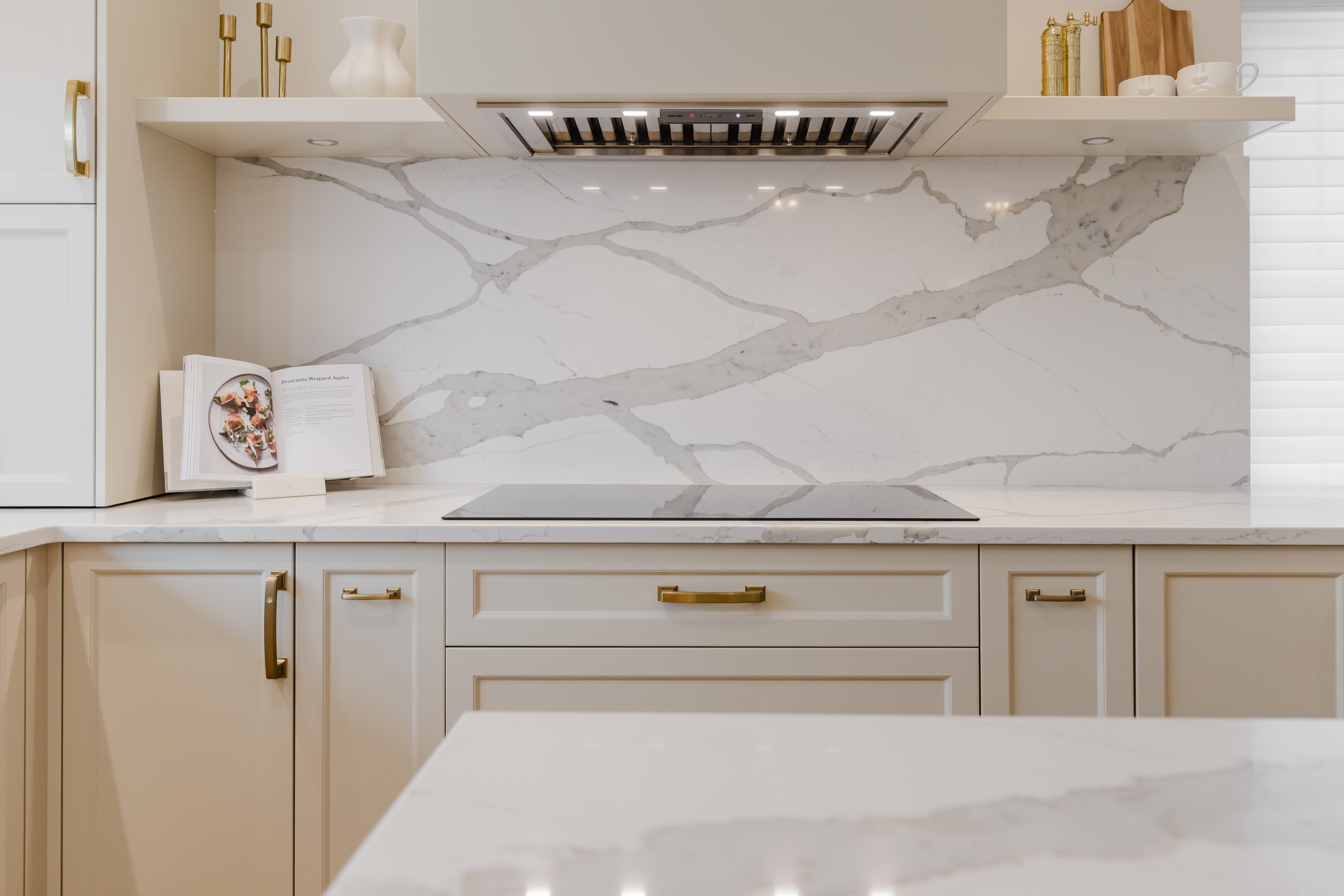 Experience the perfect blend of elegance and functionality in this modern kitchen featuring soft cabinetry and a stunning marble backsplash.