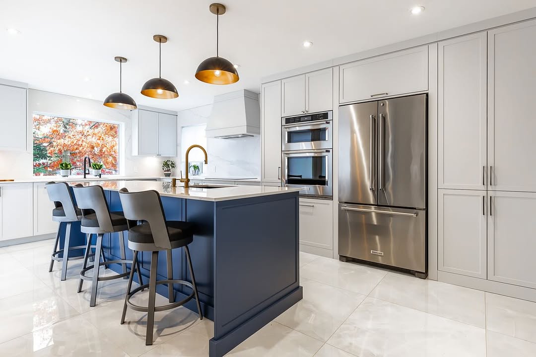 Modern kitchen featuring a striking navy island, sleek gray cabinetry, and vibrant artwork for a stylish and inviting culinary space.