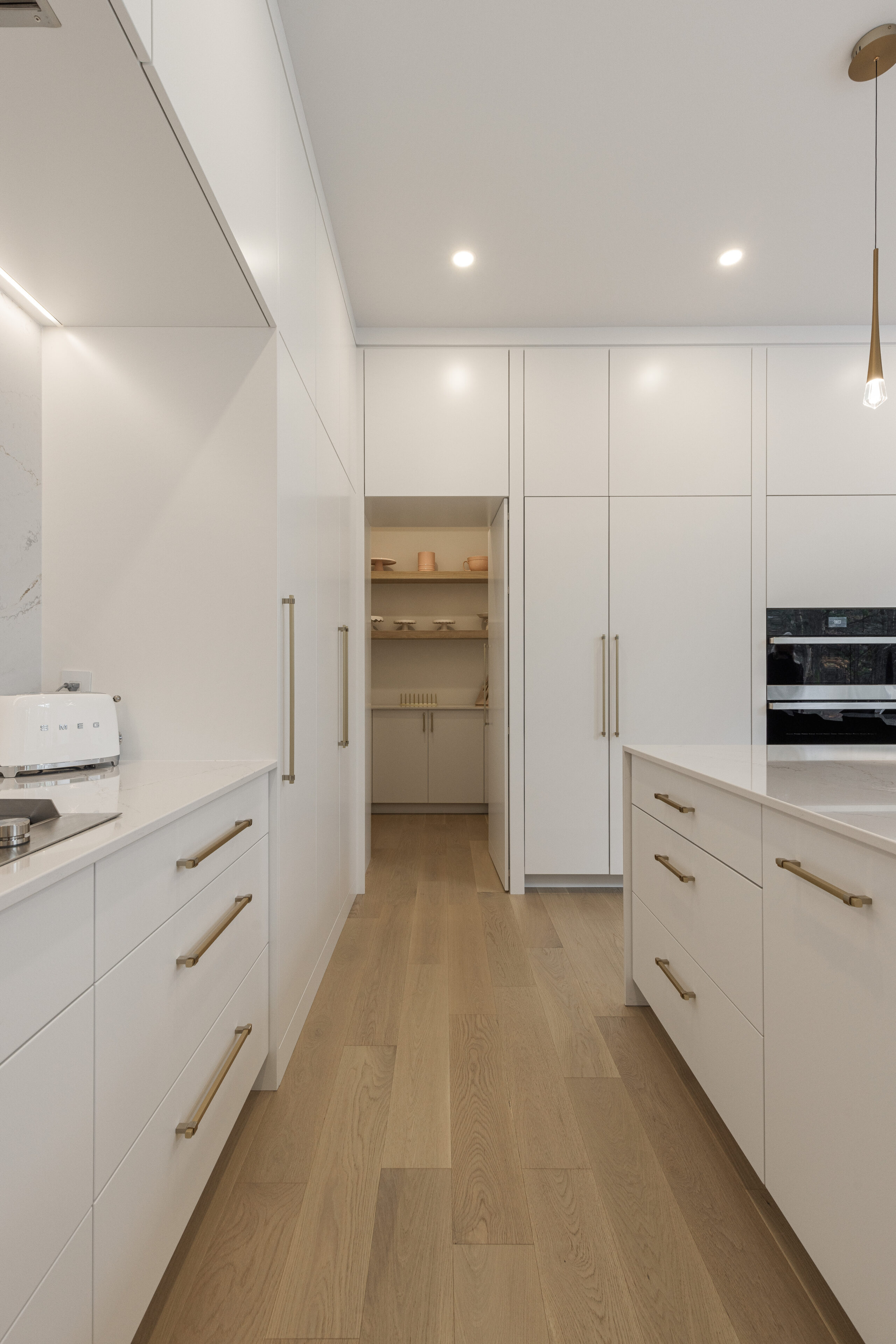 Modern kitchen showcasing sleek white cabinetry, polished countertops, and warm wooden accents that blend style and functionality seamlessly.