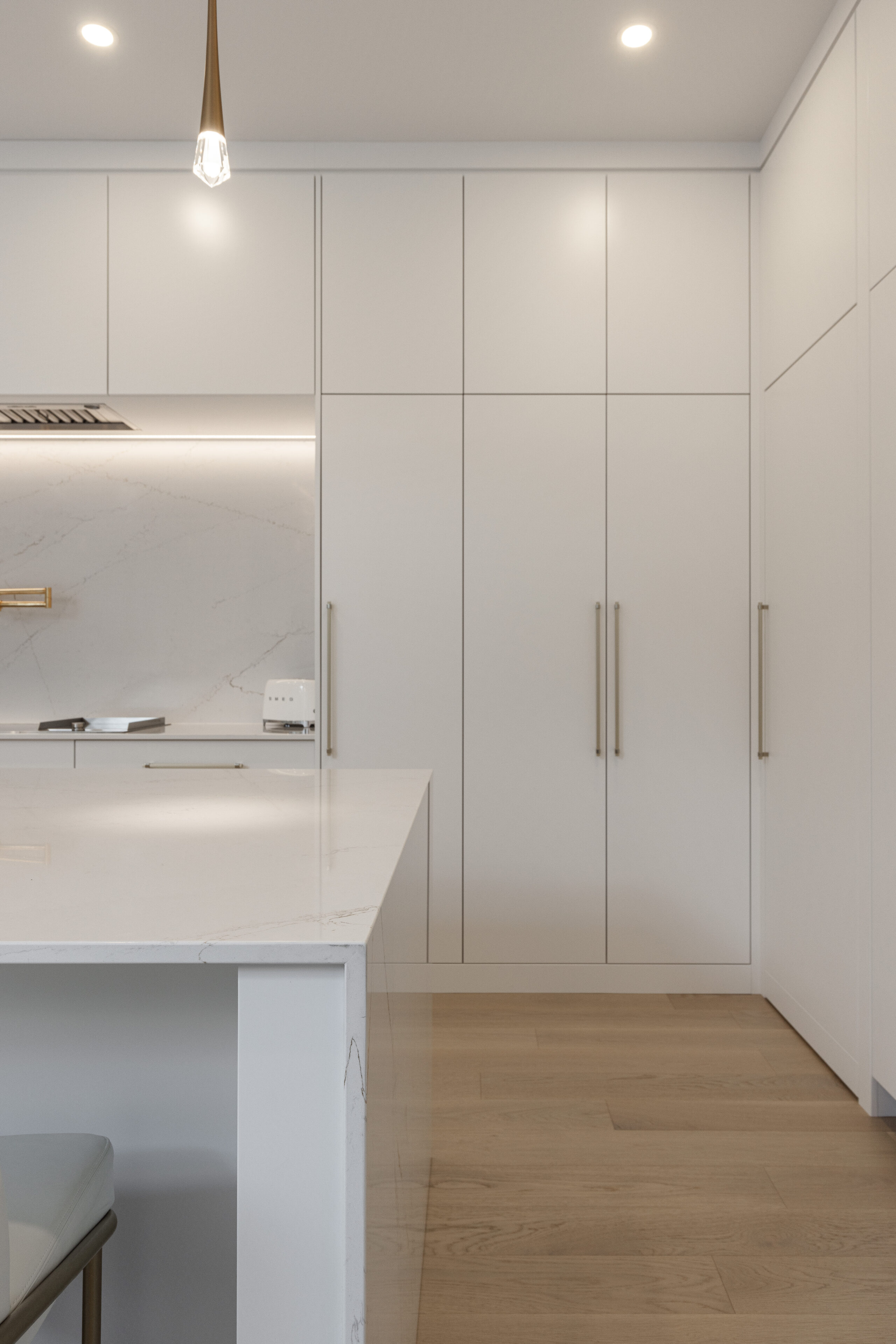 Discover a sleek minimalist kitchen with a spacious island, glossy cabinetry, and warm lighting for an inviting cooking experience.