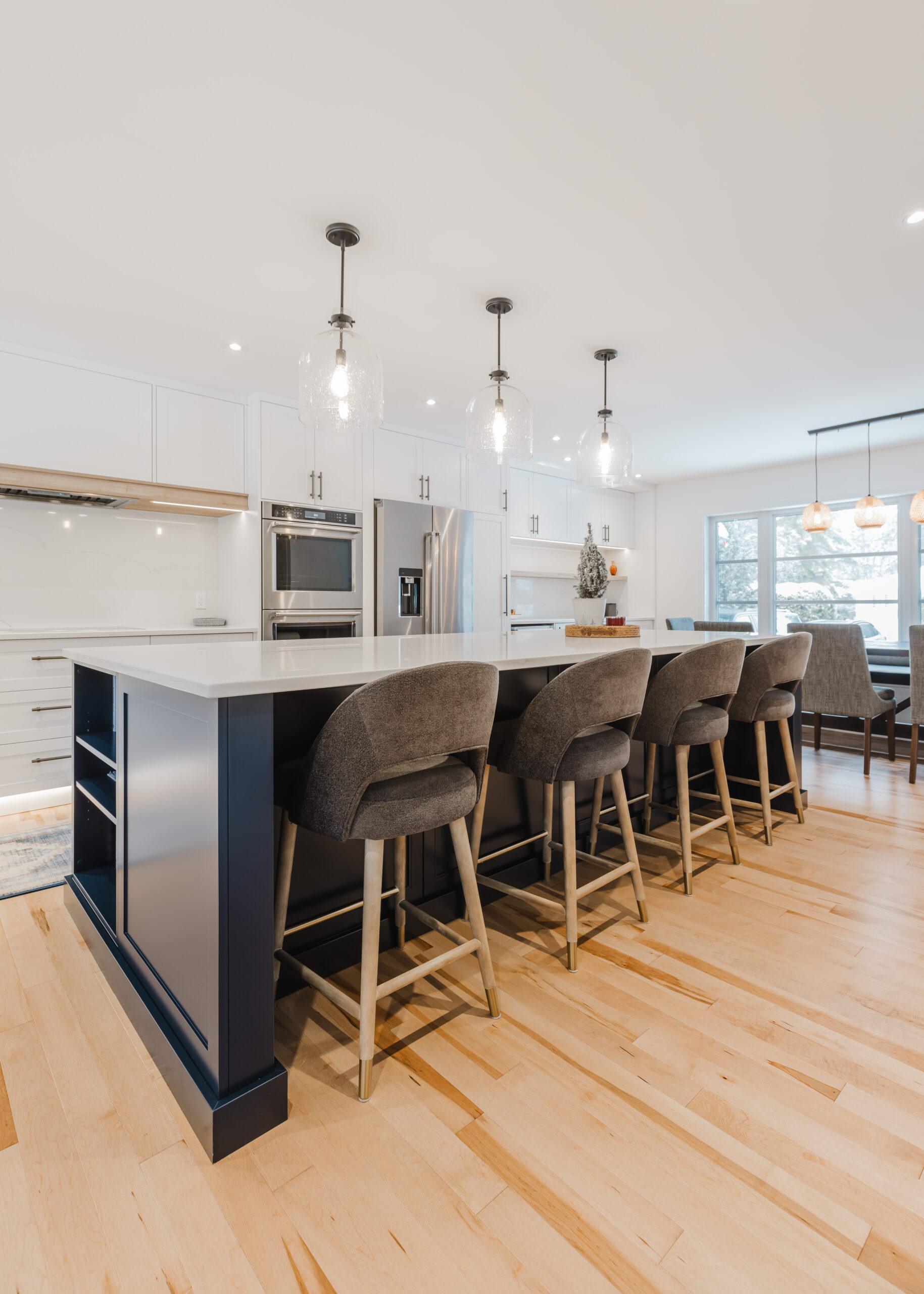 Inviting modern kitchen with navy cabinetry, white countertops, and natural light for comfortable gatherings.