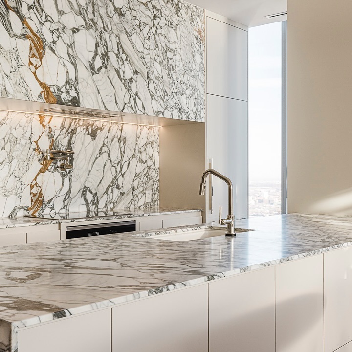 Discover a luxurious modern kitchen featuring stunning marble accents and bright natural light for an elegant and inviting space.