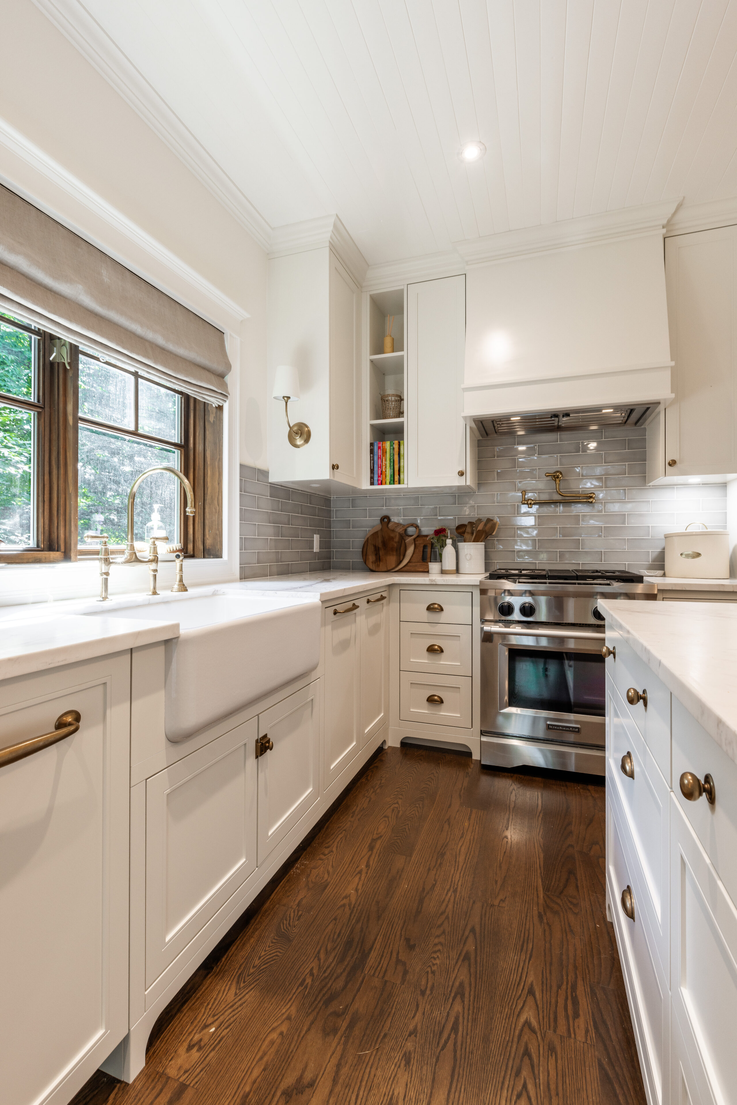 Experience the perfect blend of modern elegance and functionality in this bright kitchen featuring white cabinetry and a chic herringbone backsplash.
