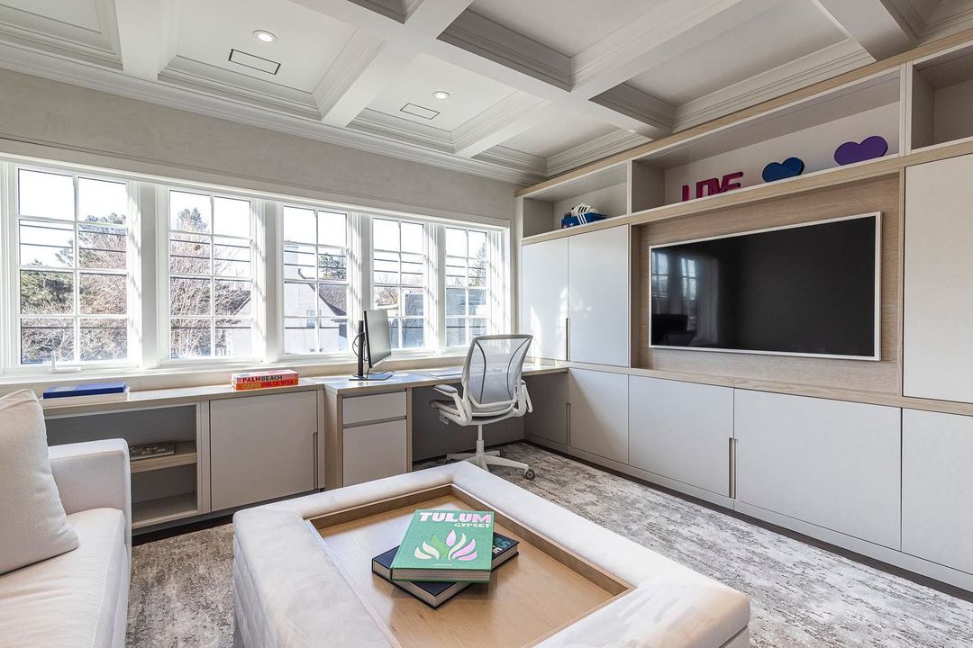 Bright and modern home office showcasing natural light, a sleek desk, and a cozy sofa, perfect for productive work and relaxation.