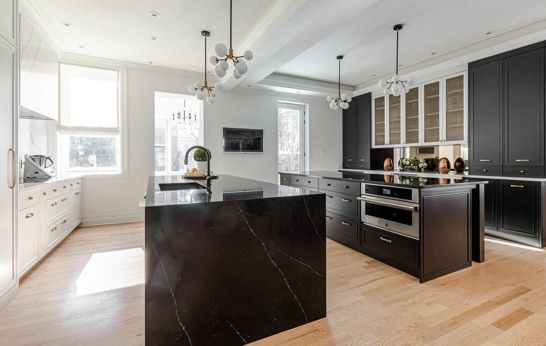 Modern kitchen featuring a striking black marble island, sleek black cabinetry, and a bright, airy atmosphere with natural light.