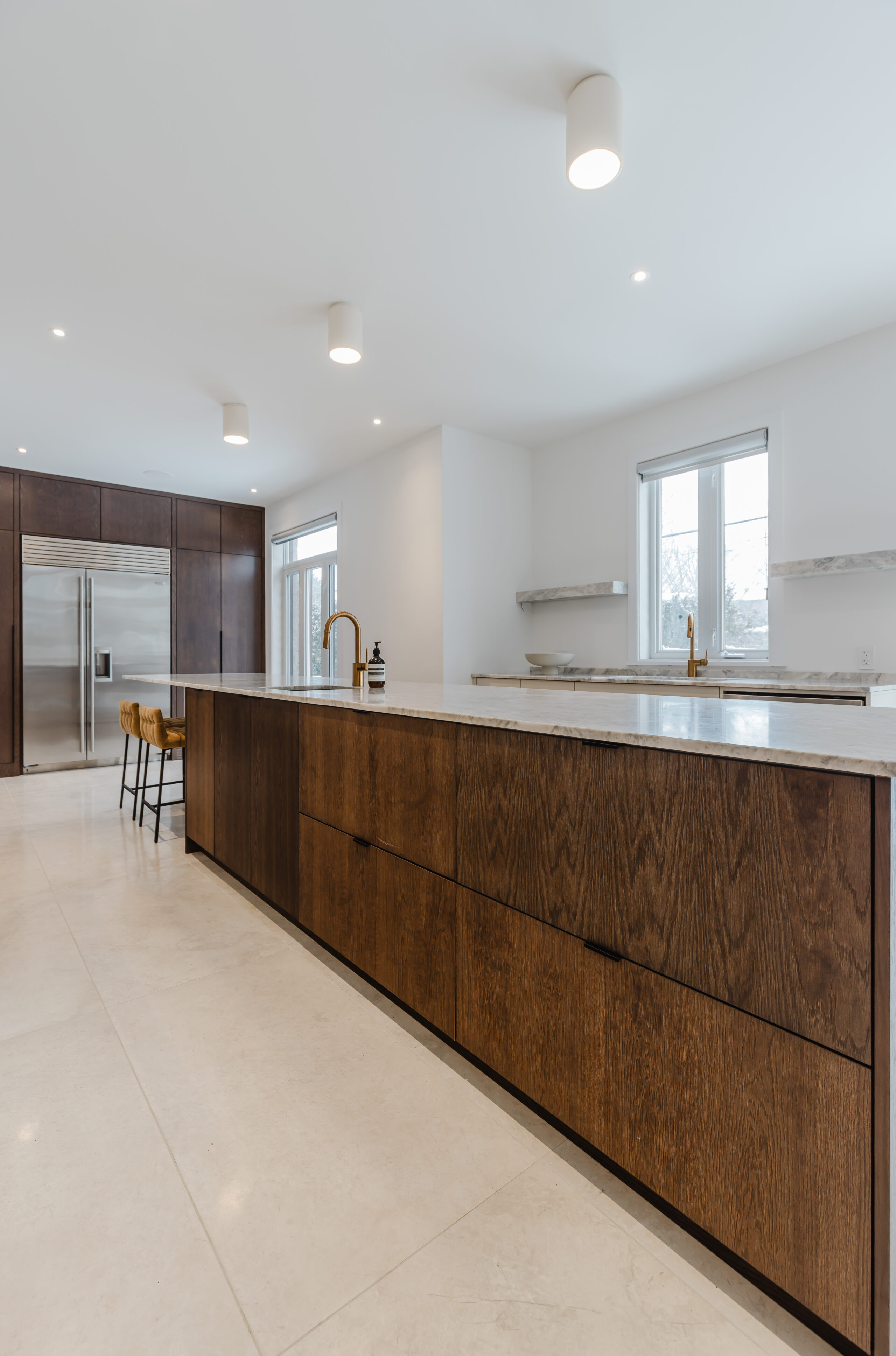 Experience a stylish modern kitchen with a sleek island, high-end appliances, and natural light, perfect for cooking and social gatherings.