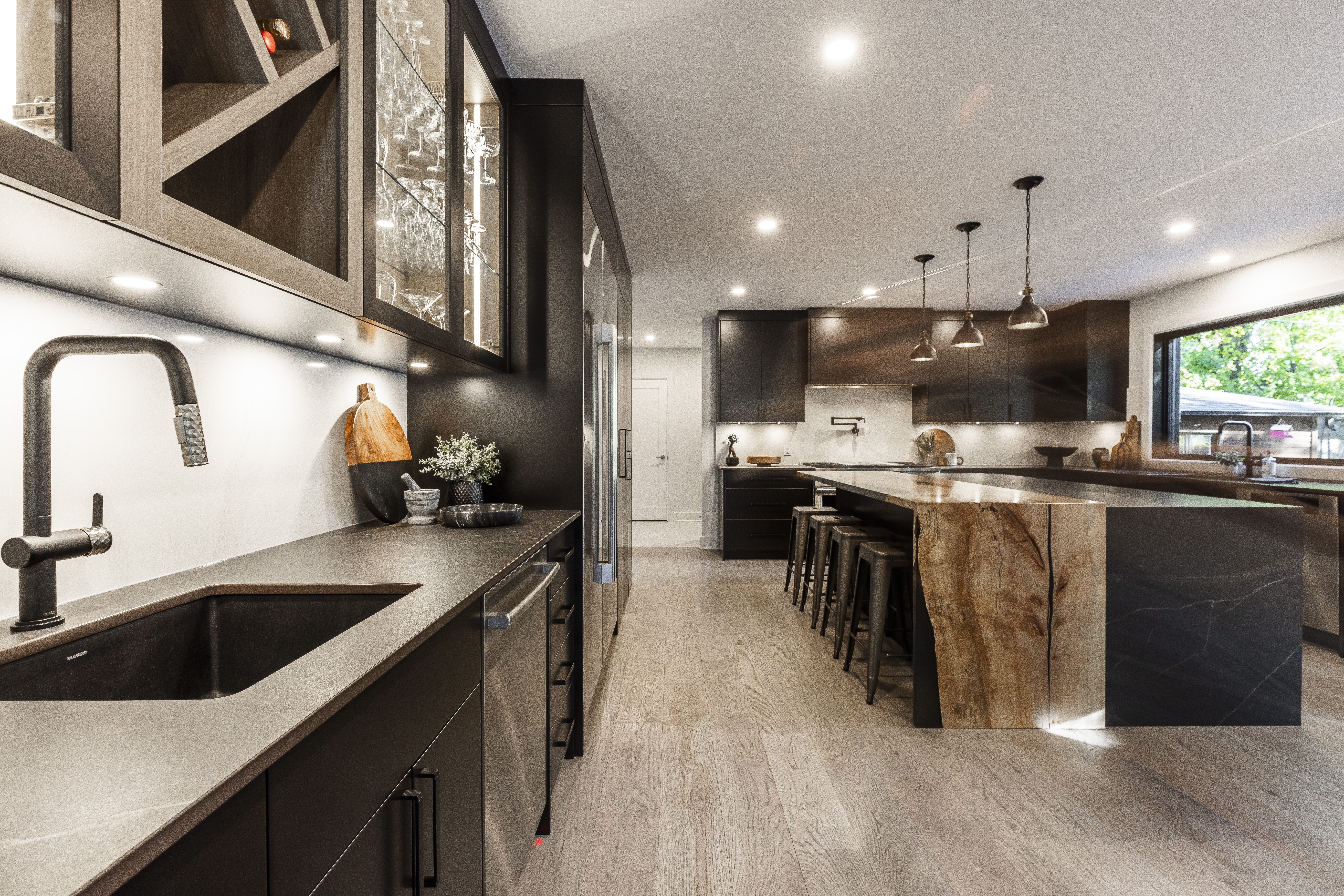 Stunning modern kitchen featuring dark cabinetry, a wood island, and abundant natural light for a perfect blend of style and functionality.