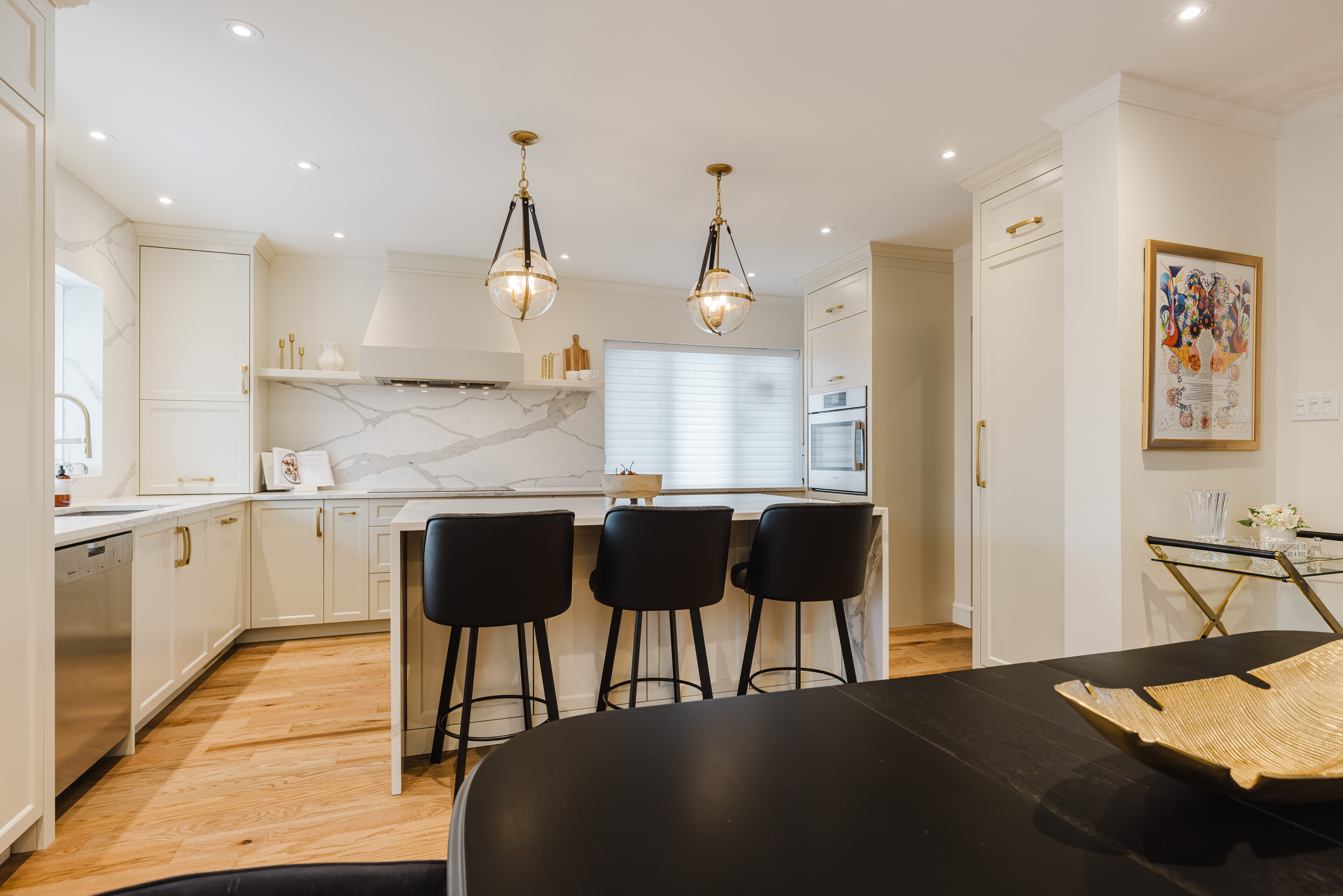 Bright and elegant modern kitchen featuring cream cabinetry, luxury marble countertops, and a stylish multifunctional island for cooking and socializing.