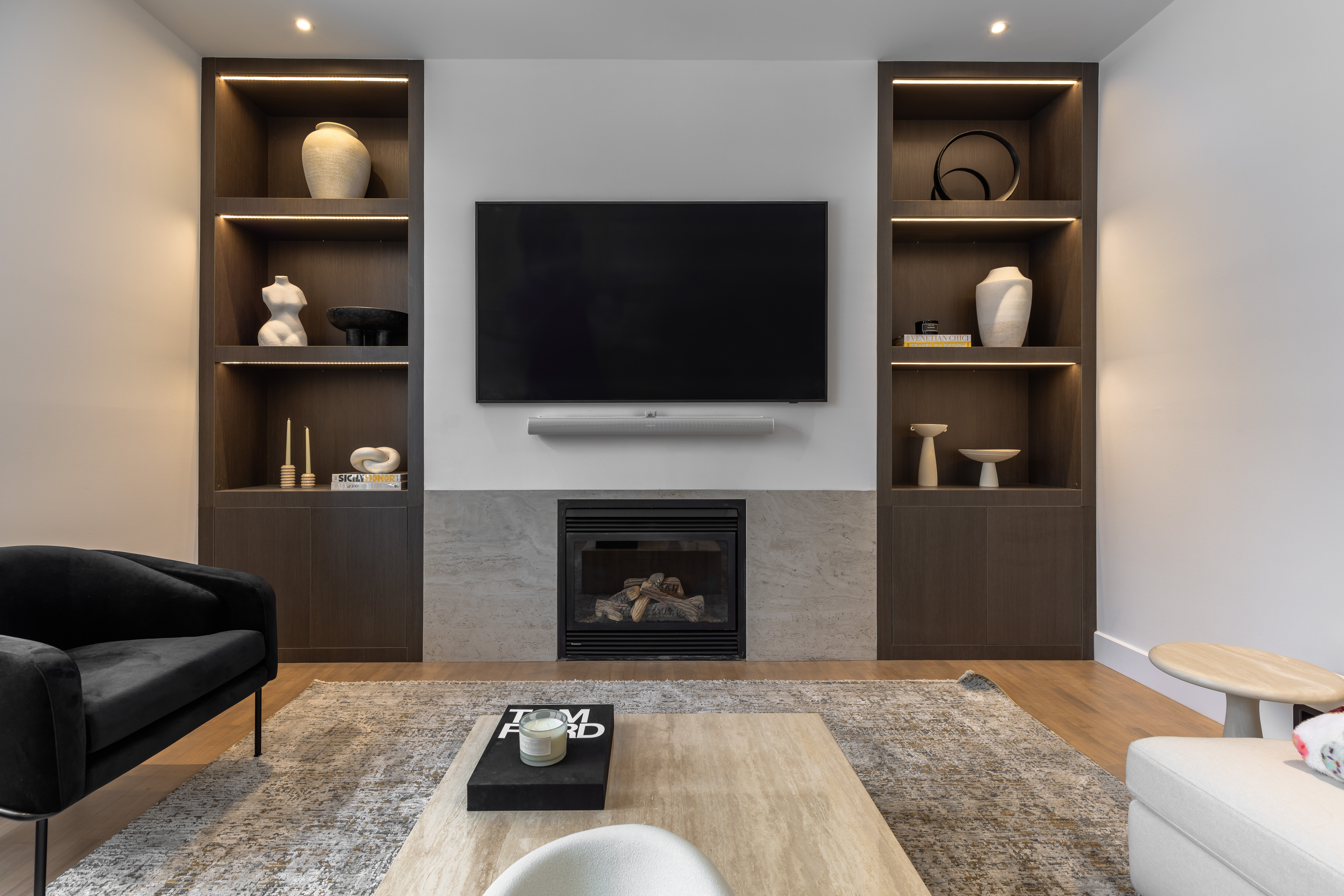 A sleek modern living room features a cozy fireplace, minimalist furnishings, and elegant decor for a warm and inviting ambiance.