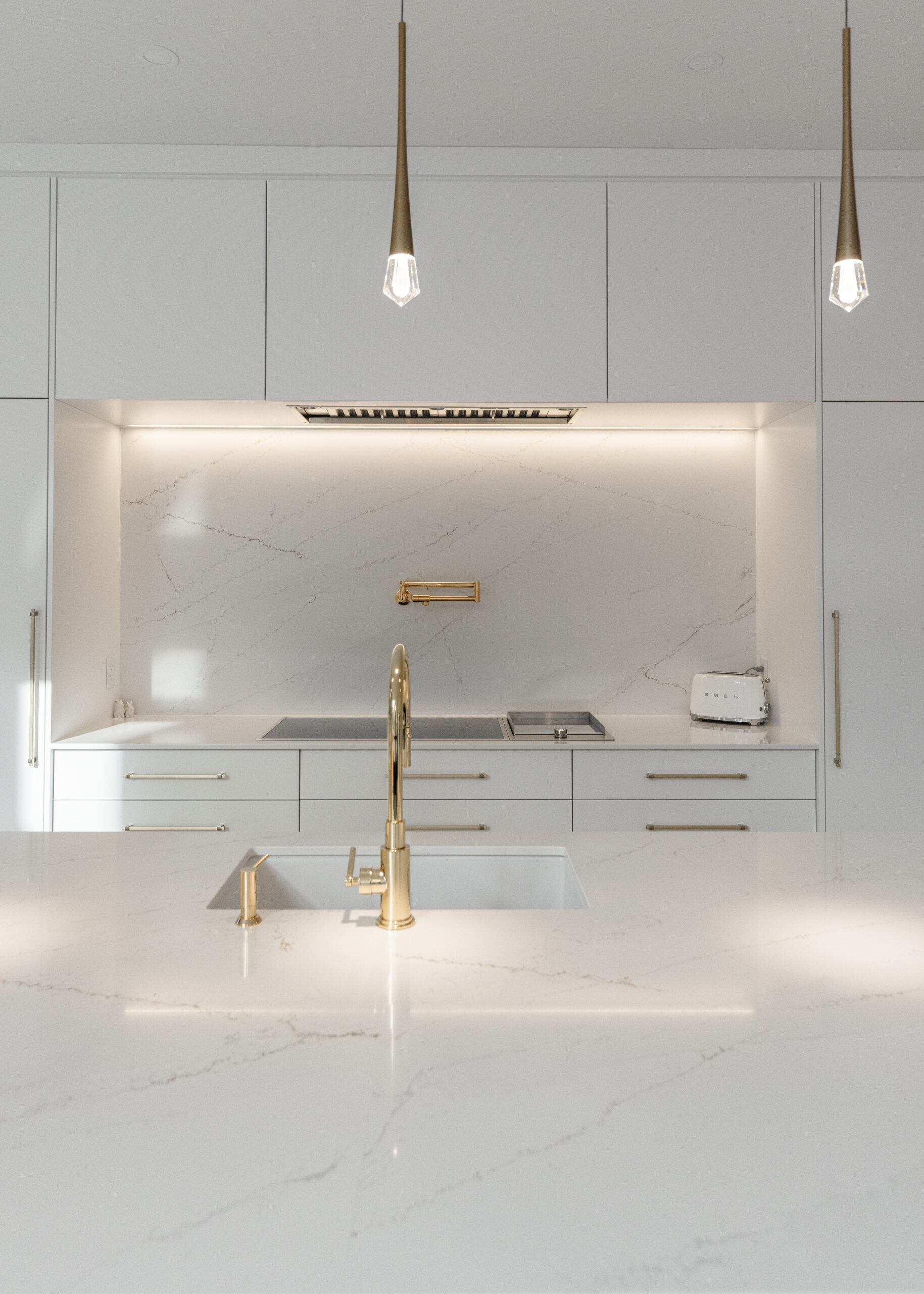 Sleek white cabinetry and polished stone countertops create a luxurious ambiance in this elegant modern minimalist kitchen.