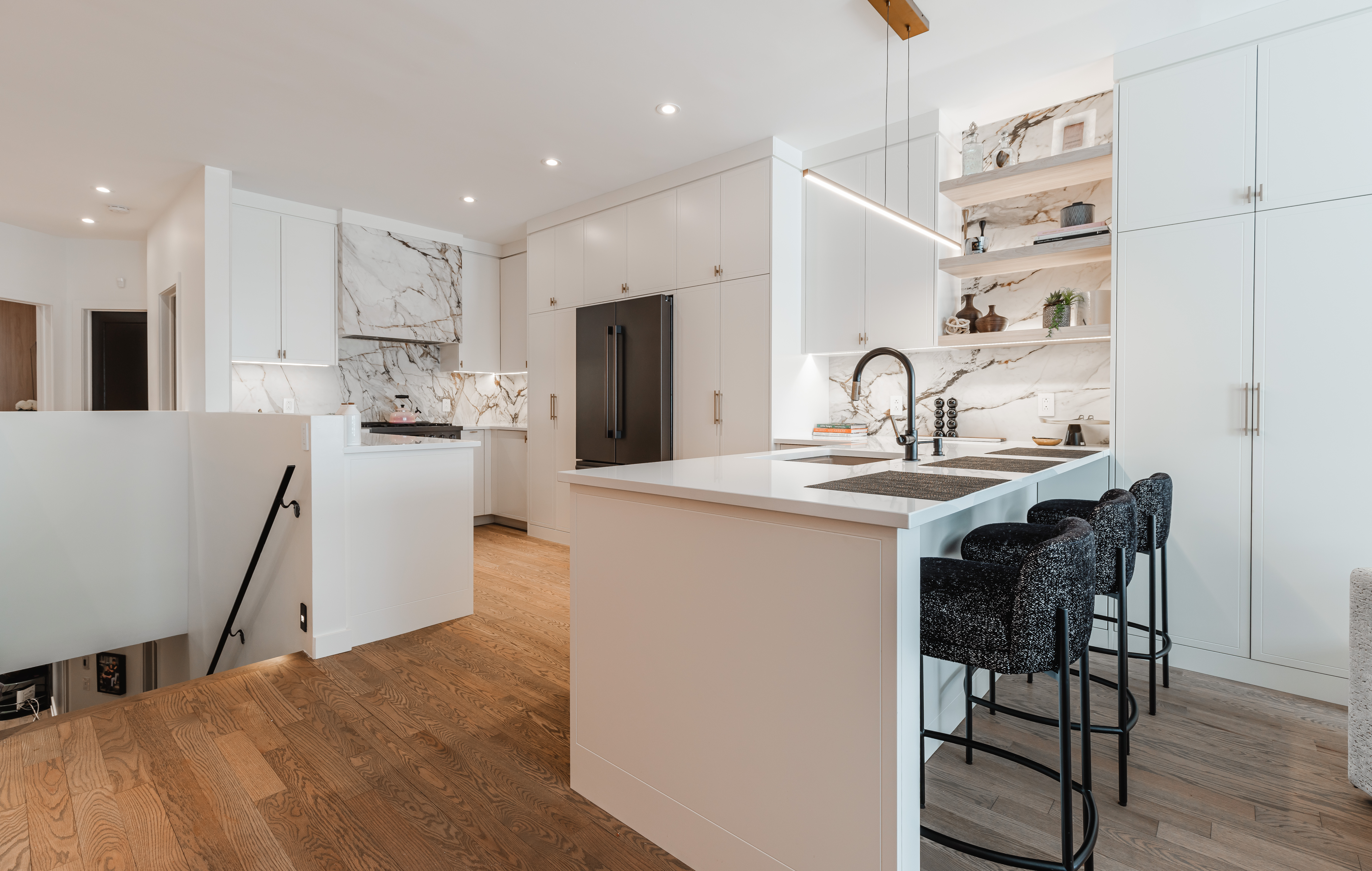 Discover this modern minimalist kitchen featuring sleek white cabinetry, a stylish island, and warm wooden accents for an inviting space.