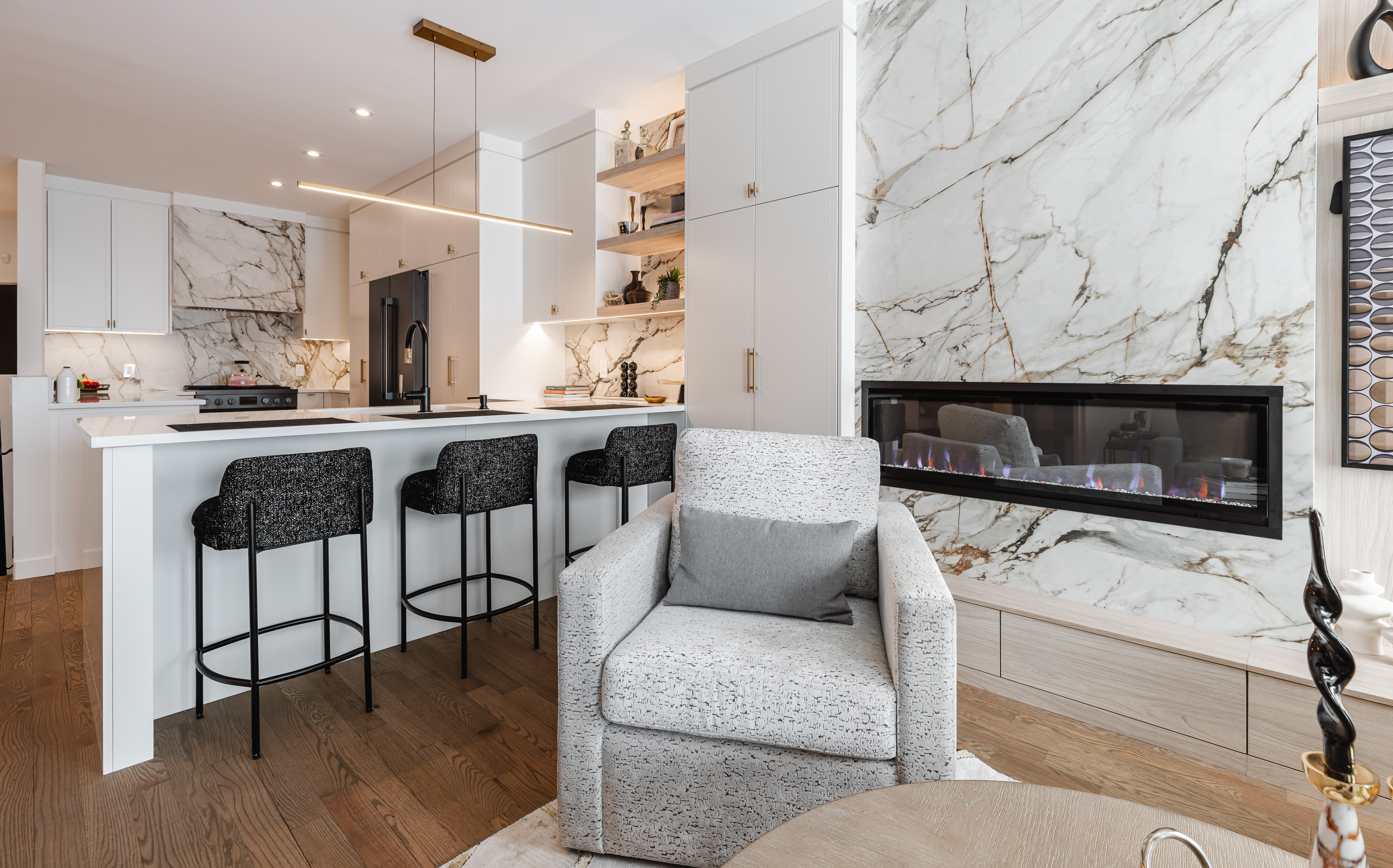 Discover a chic open-concept living space that blends modern elegance with cozy comfort, featuring a stunning marble accent wall.