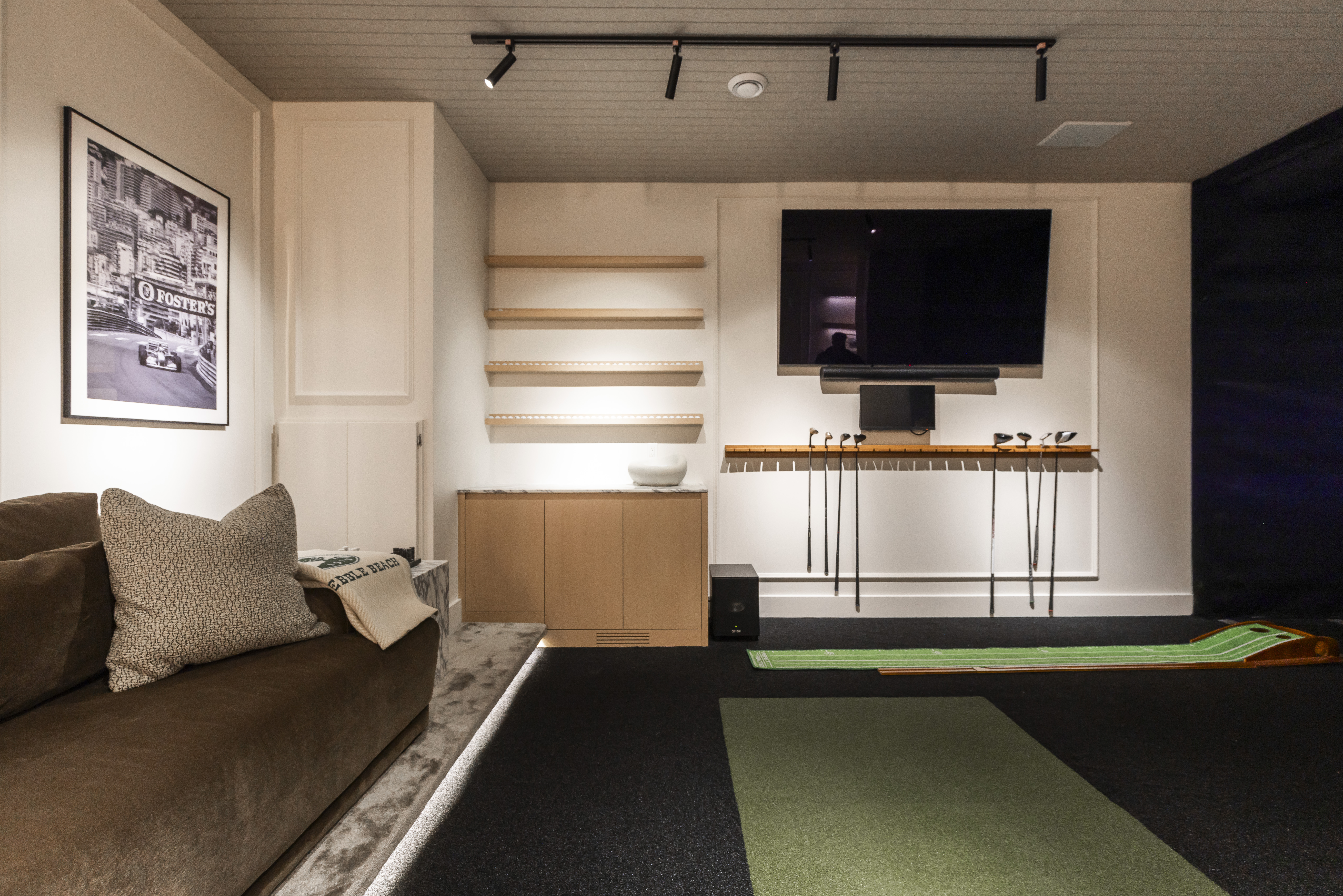 Relax in this cozy modern room featuring a plush brown sofa, stylish art, and a vibrant green mat for a perfect leisure retreat.