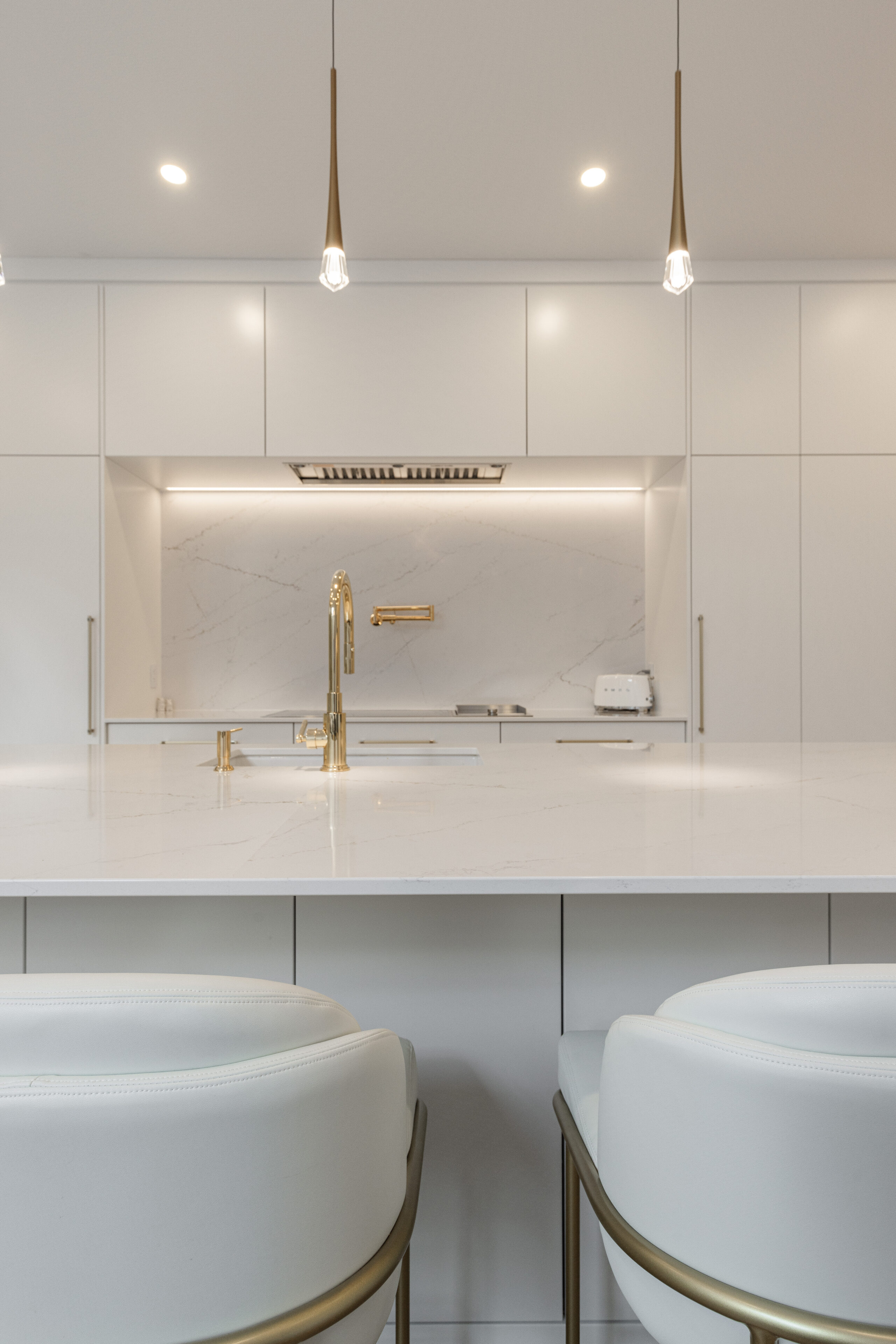 Discover a sleek modern kitchen with light cabinetry, an elegant island, and warm gold accents that blend style with functionality.