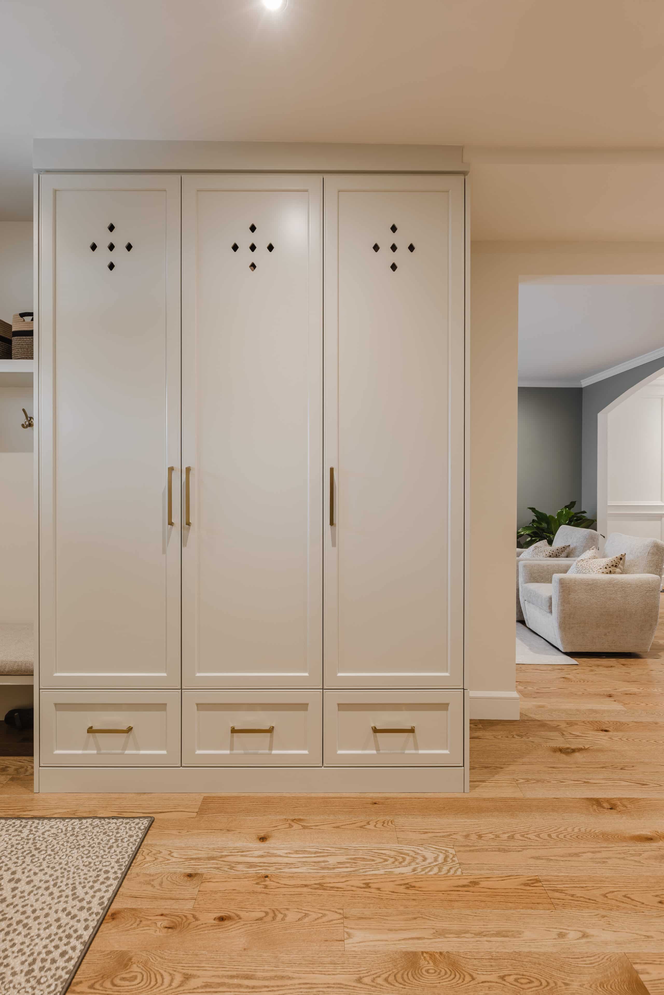 Stylish cream wardrobe blends modern design with cozy decor, enhancing the inviting atmosphere of the warm wooden-floored room.