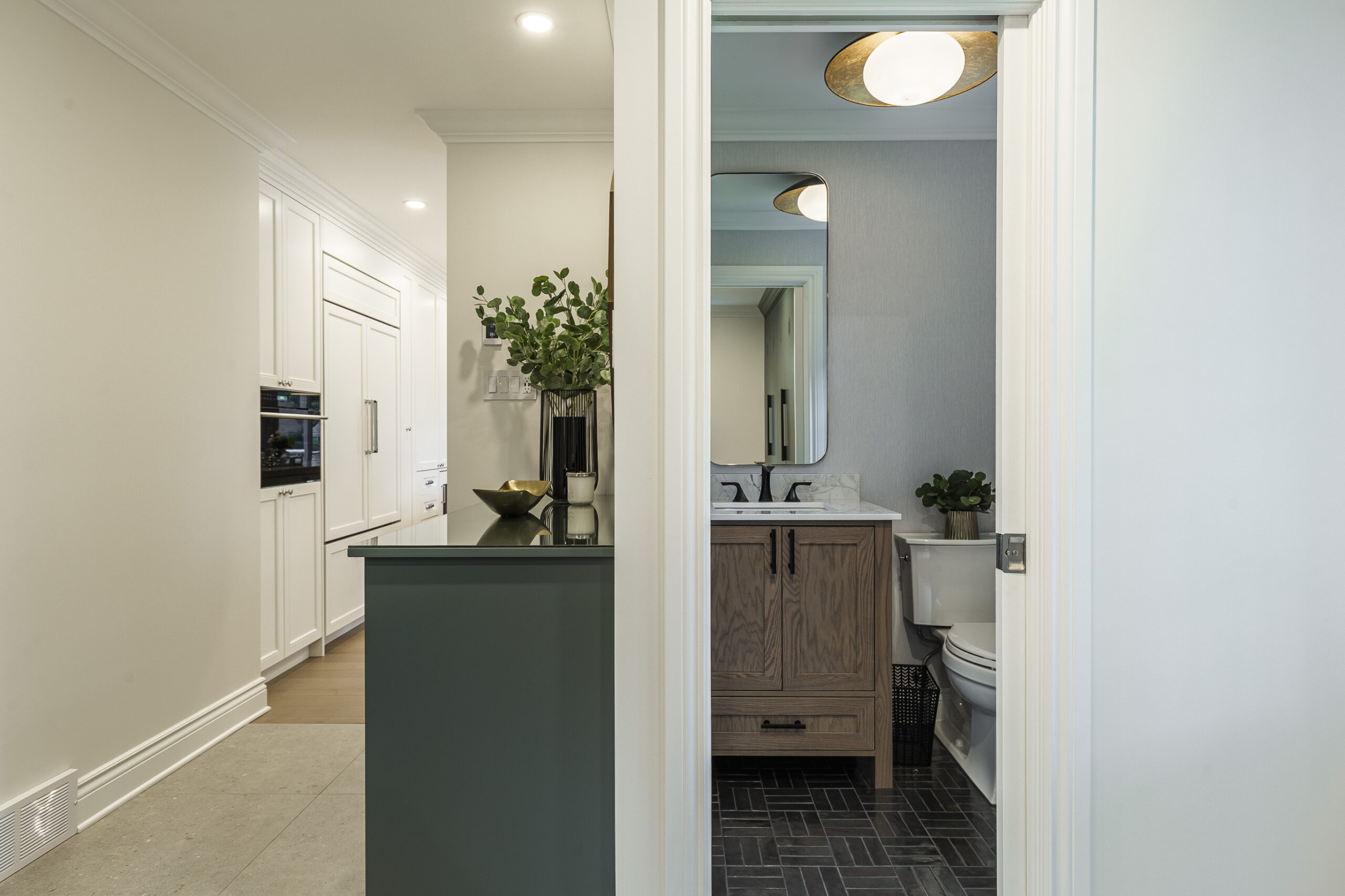 Stylish modern bathroom featuring a warm wood vanity, serene potted plants, and inviting soft lighting for a tranquil ambiance.