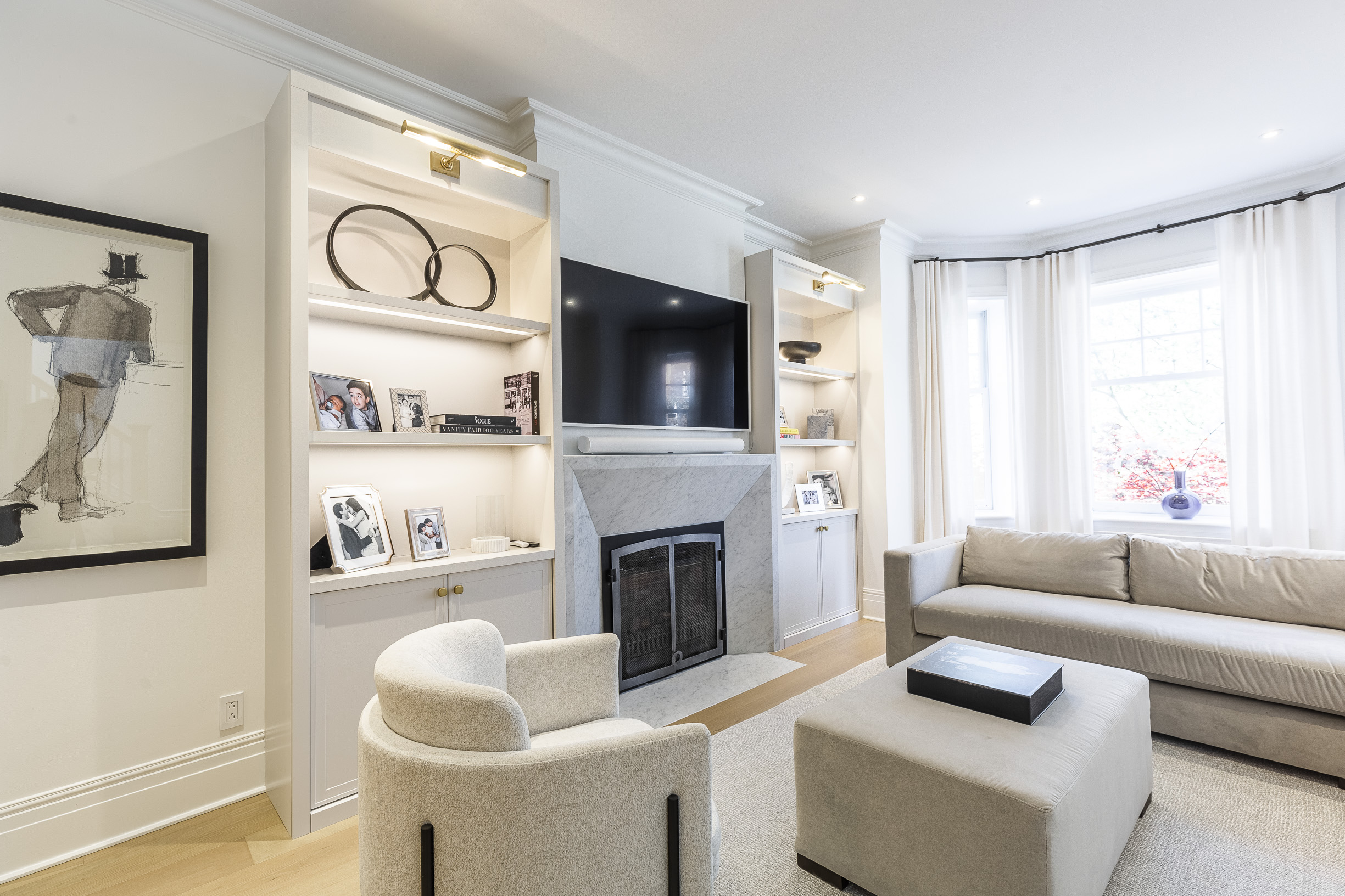 Elevate your relaxation in this modern living room, featuring a serene neutral palette, natural light, and stylish built-in shelving.