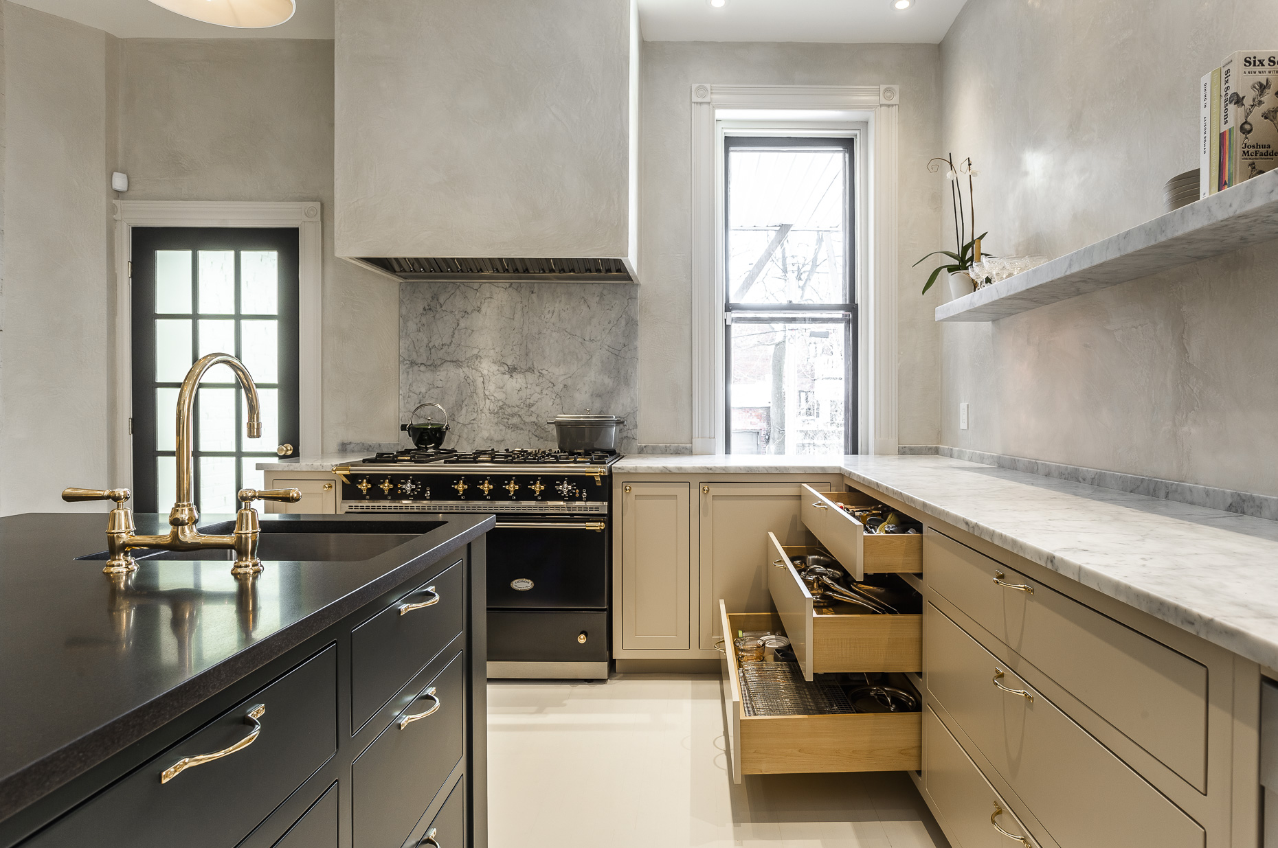 Discover a chic modern kitchen featuring a stylish black island, professional-grade appliances, and abundant natural light for a welcoming atmosphere.