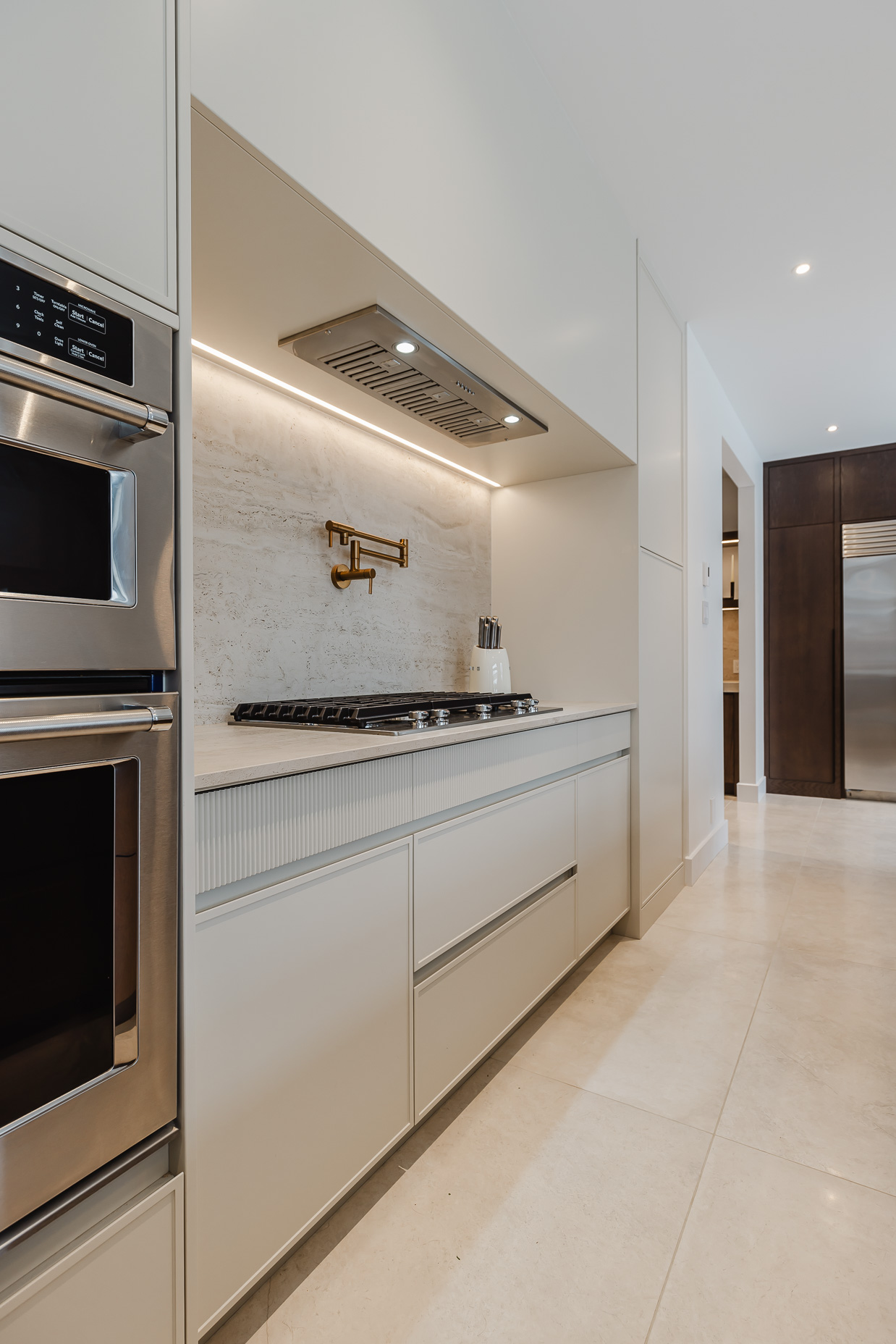 Discover a sleek modern kitchen featuring white cabinetry, a polished countertop, and stainless steel appliances for a stylish, functional space.