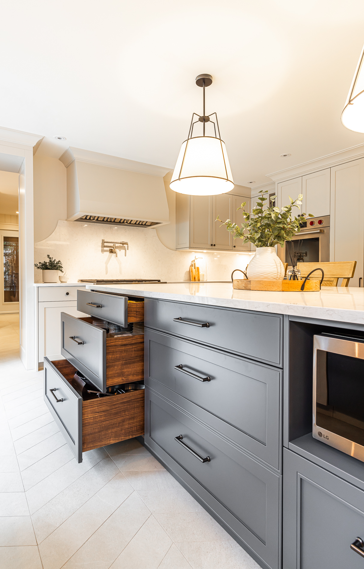 Stylishly modern gray kitchen featuring a welcoming island, warm lighting, and a chic herringbone tile floor for the perfect cooking space.