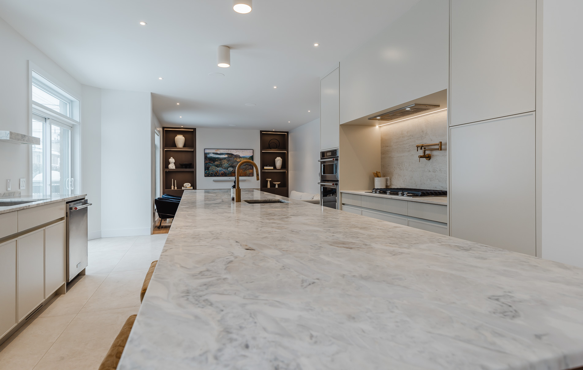A sleek modern kitchen features a stunning marble island, stylish cabinetry, and integrated appliances for elegant cooking and gatherings.