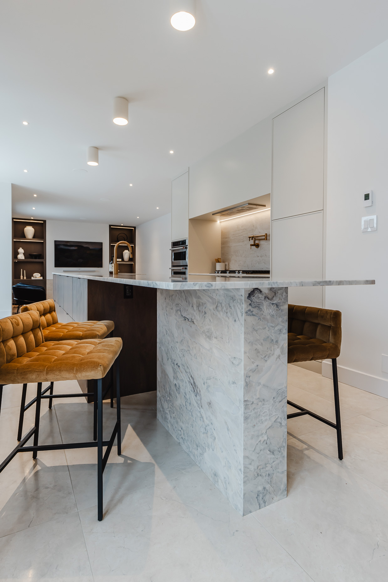 Experience modern elegance in this open-concept kitchen, featuring a stunning marble island and warm-toned seating for inviting gatherings.