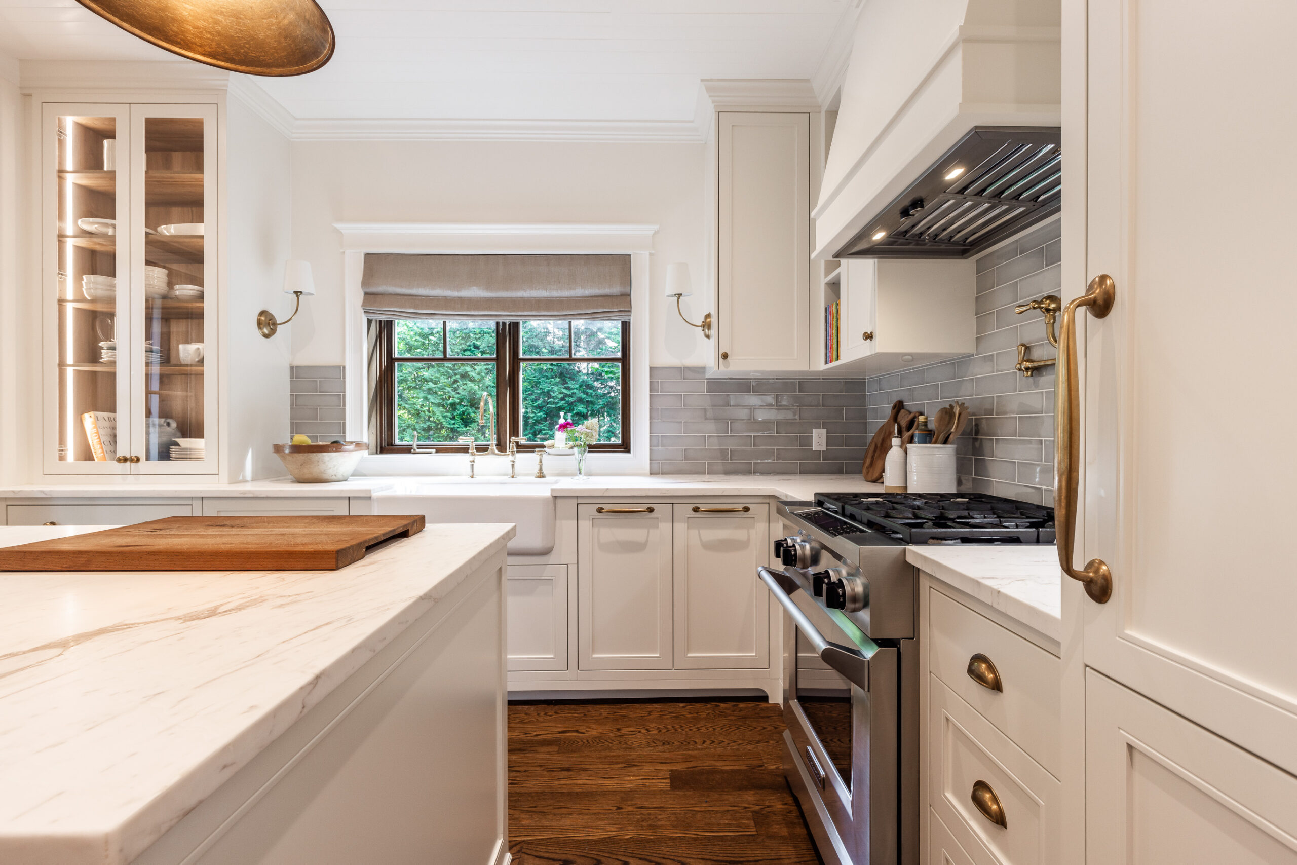 Bright white kitchen with marble countertop, modern appliances, and natural light for an inviting atmosphere.