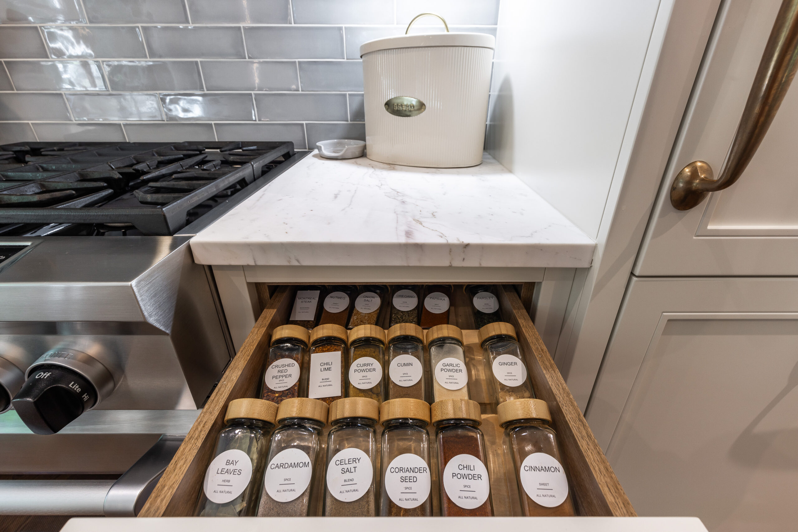 Discover a stylish kitchen with an organized spice drawer, modern stove, and elegant marble countertop for a perfect cooking experience.