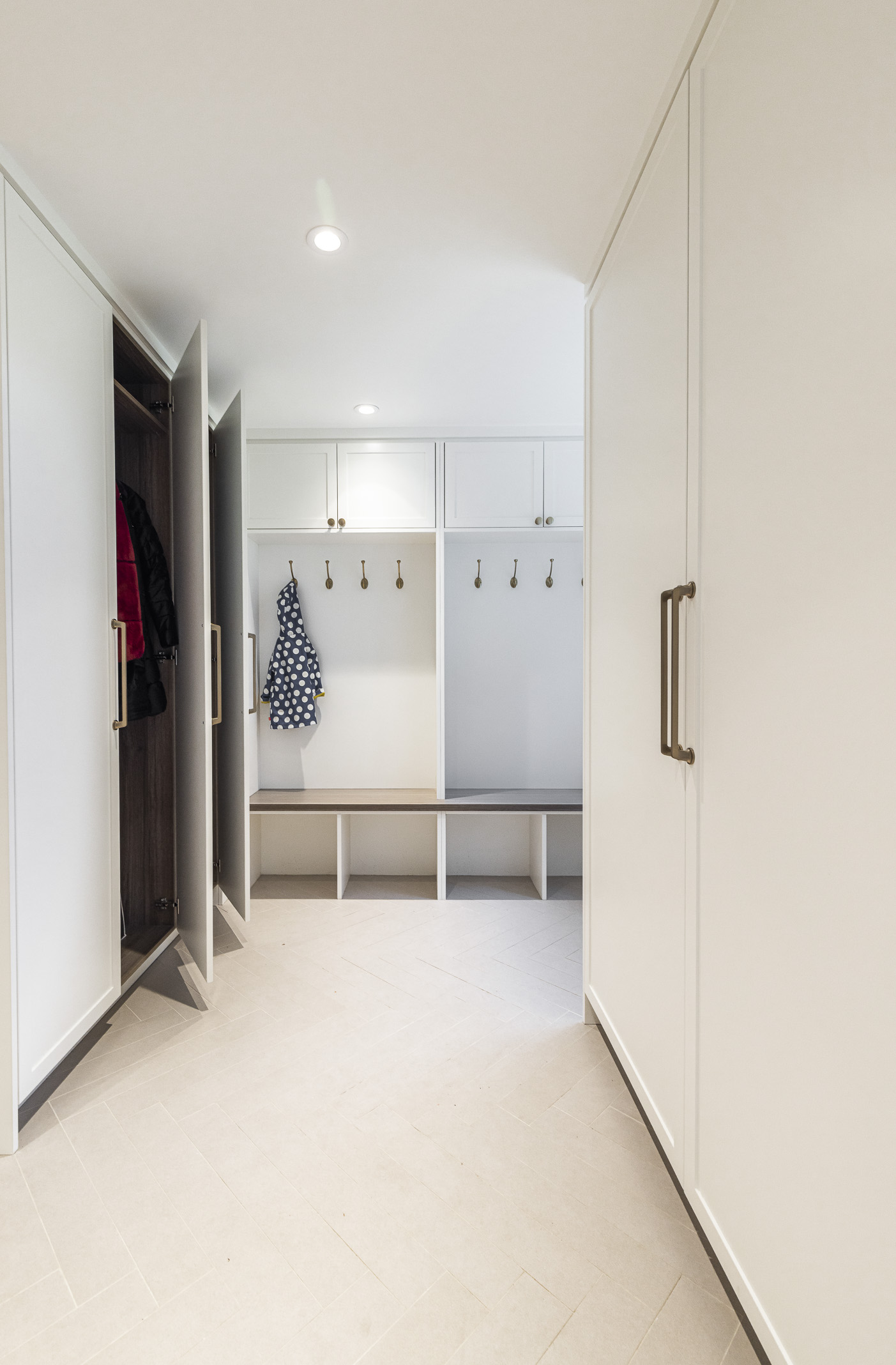 Bright and stylish minimalist entryway featuring sleek storage solutions and a practical seating area for a tidy and welcoming space.