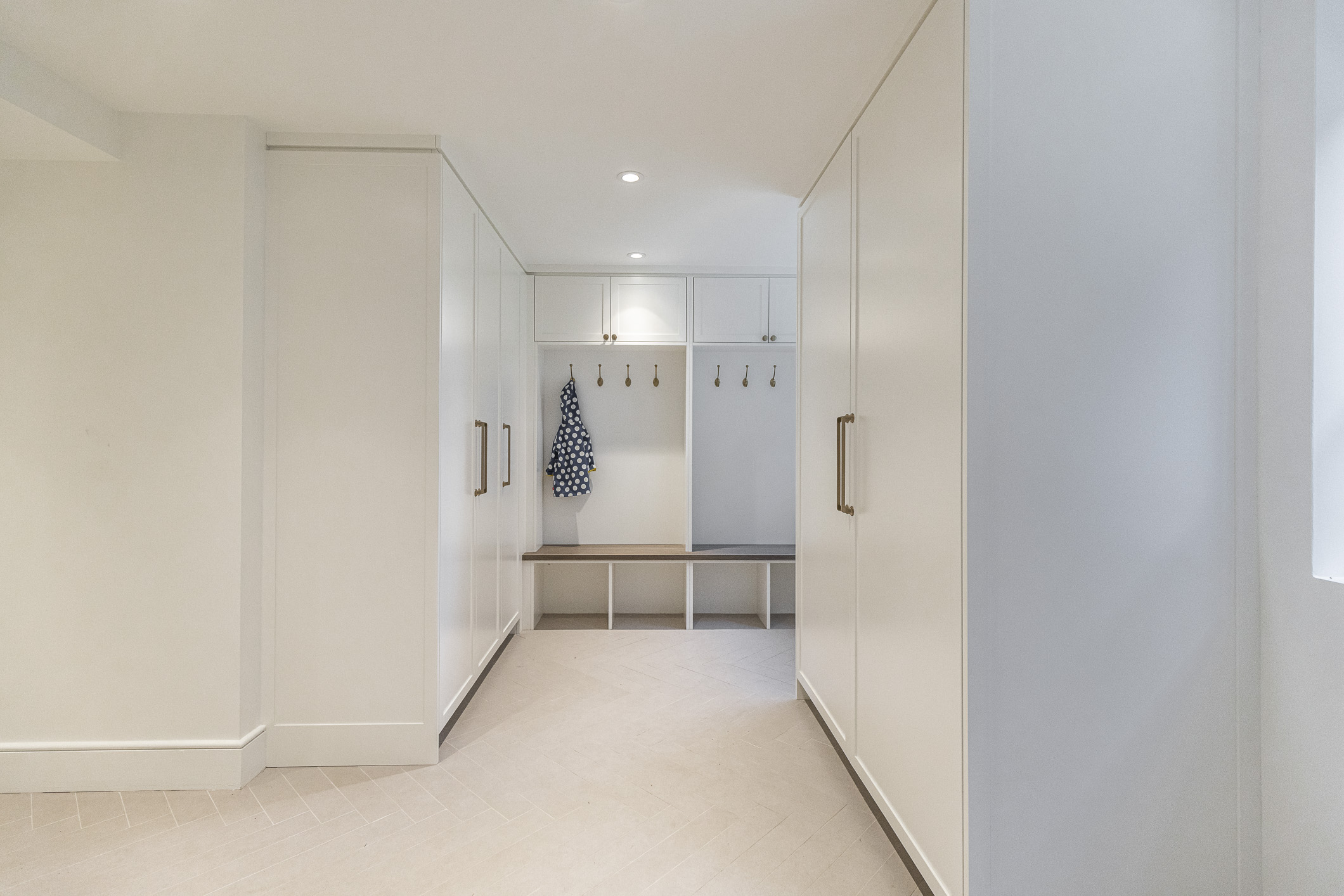 Discover a stylish minimalist hallway featuring sleek storage, functional decor, and inviting natural light for a welcoming entryway.