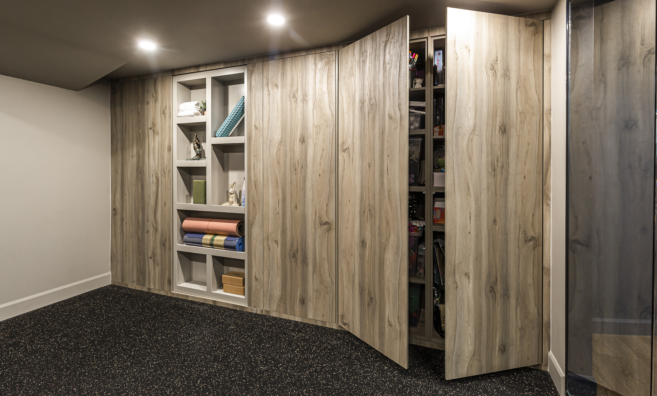 Modern basement design showcases elegant wood paneling, plush carpet, and smart storage solutions for a stylish and functional space.