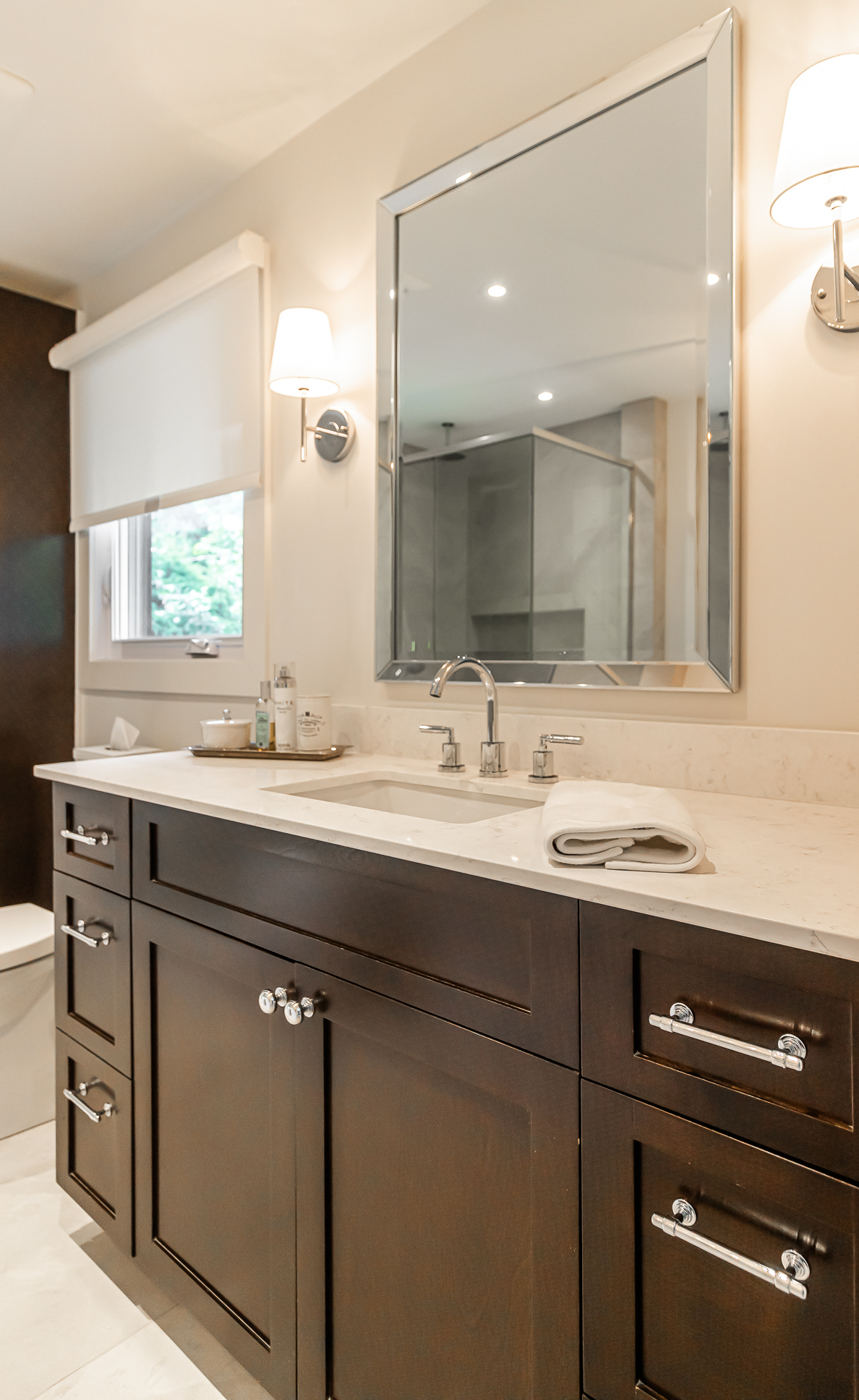 Elegant modern bathroom with dark cabinetry, light countertop, and bright accents for a serene ambiance.