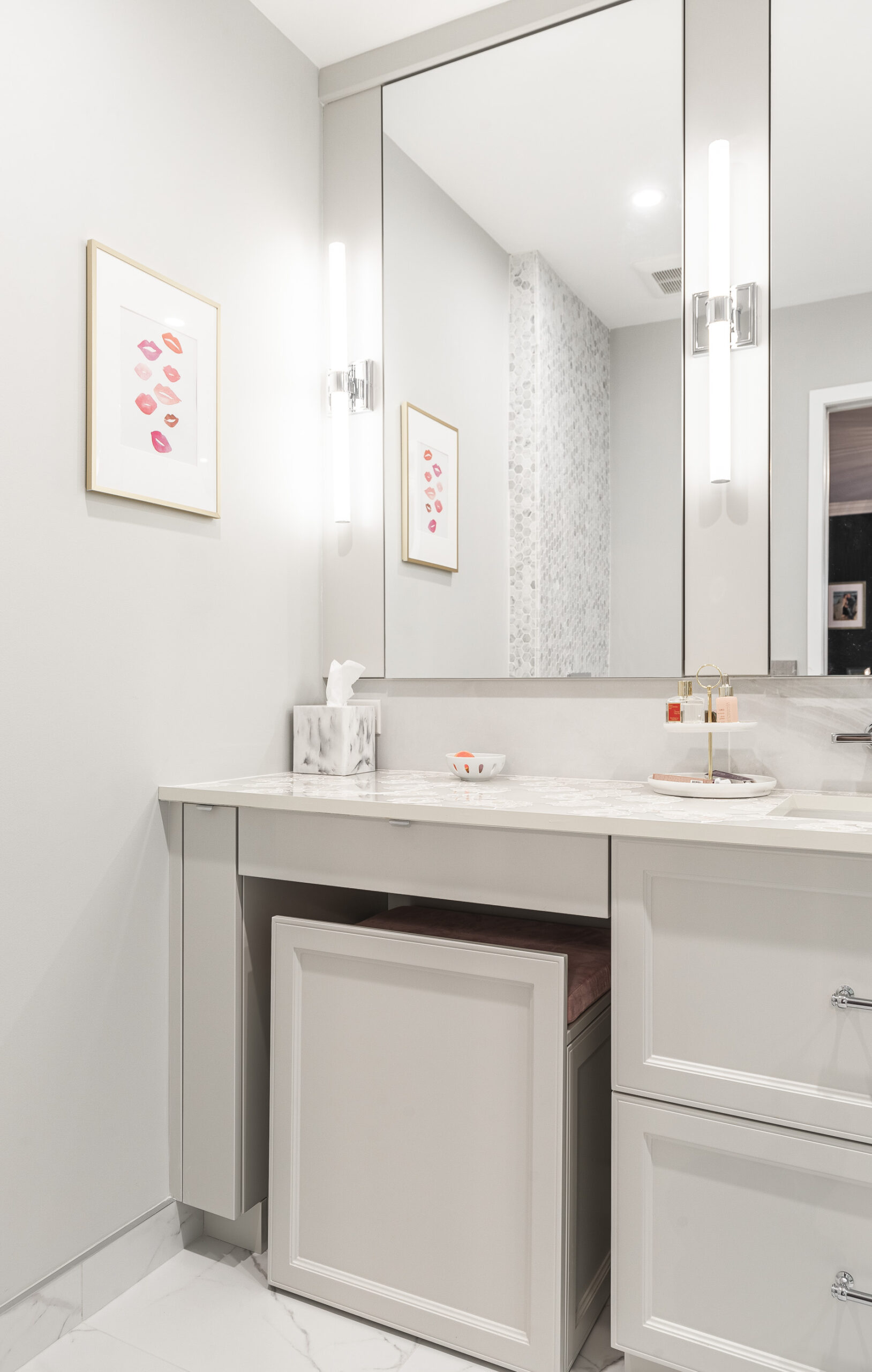 Stylish modern bathroom featuring a sleek gray vanity, elegant marble countertop, and framed art for a fresh, inviting atmosphere.
