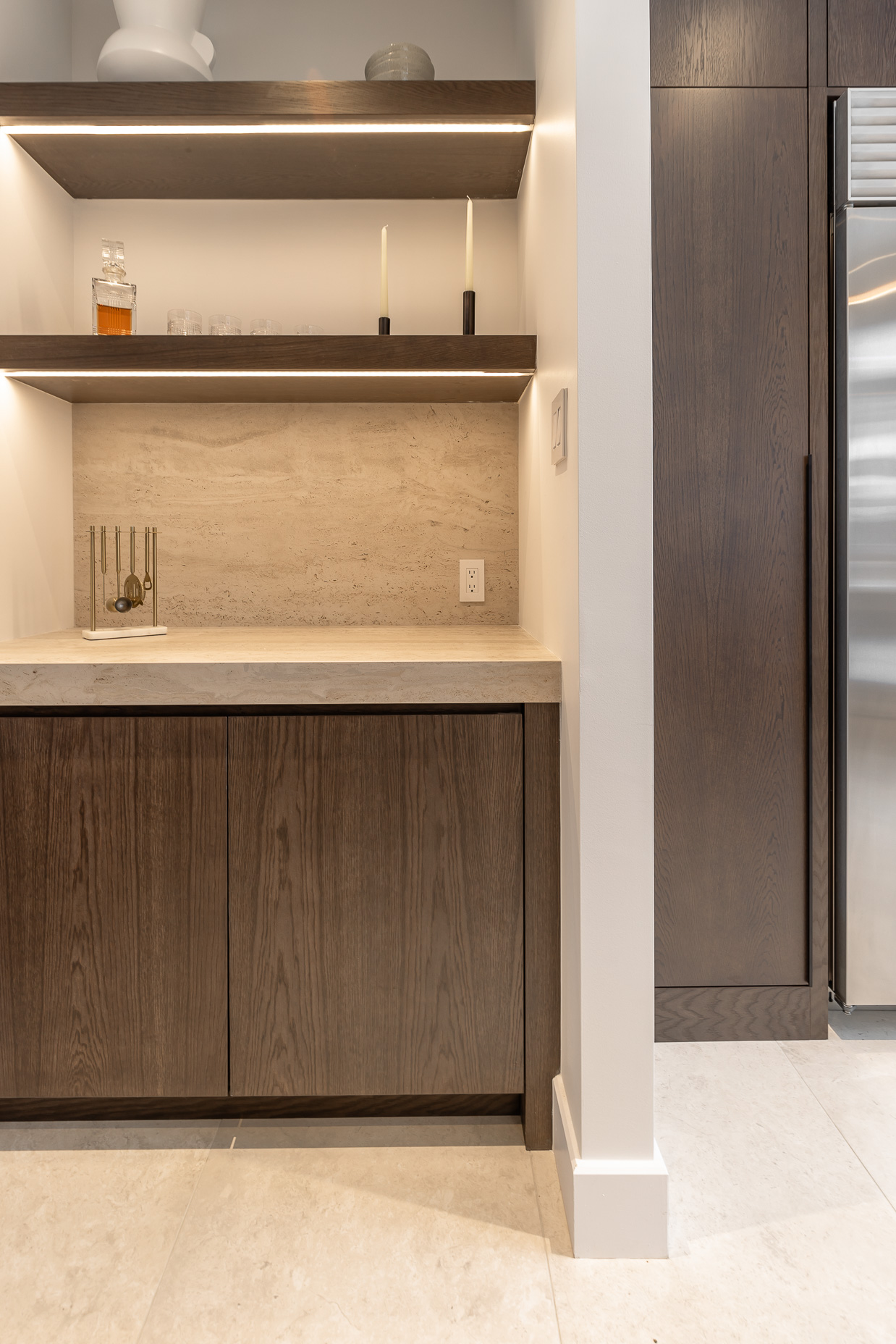 Discover a sleek modern kitchen featuring dark wood cabinetry, a light stone countertop, and stylish open shelves for a warm, inviting atmosphere.