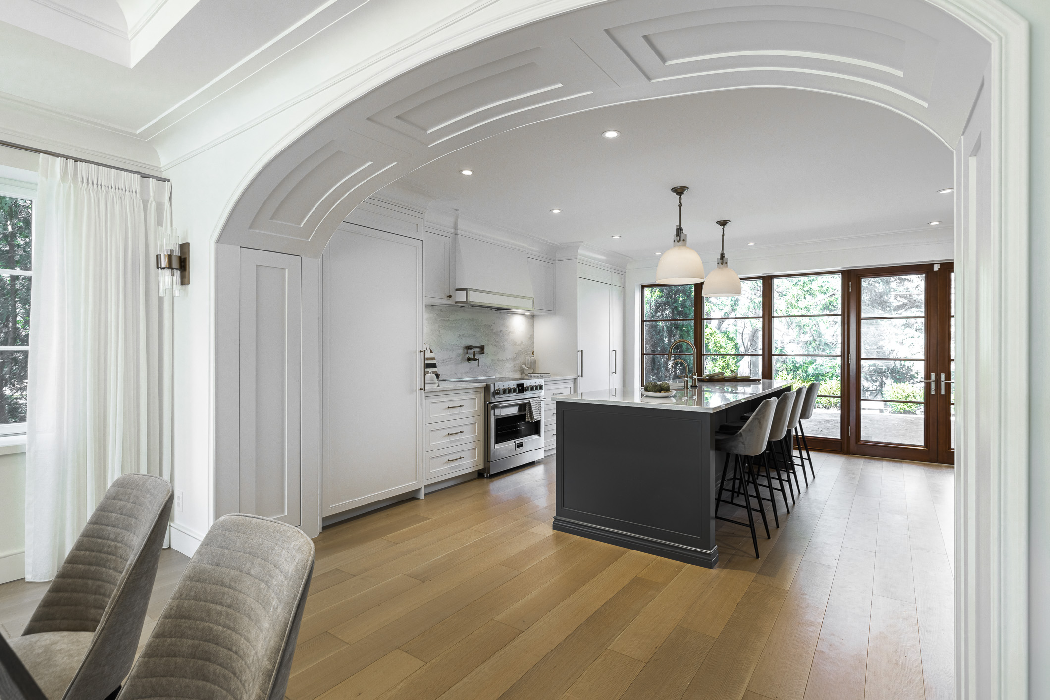 Experience the elegance of this modern kitchen featuring a spacious island, bright white cabinetry, and abundant natural light.