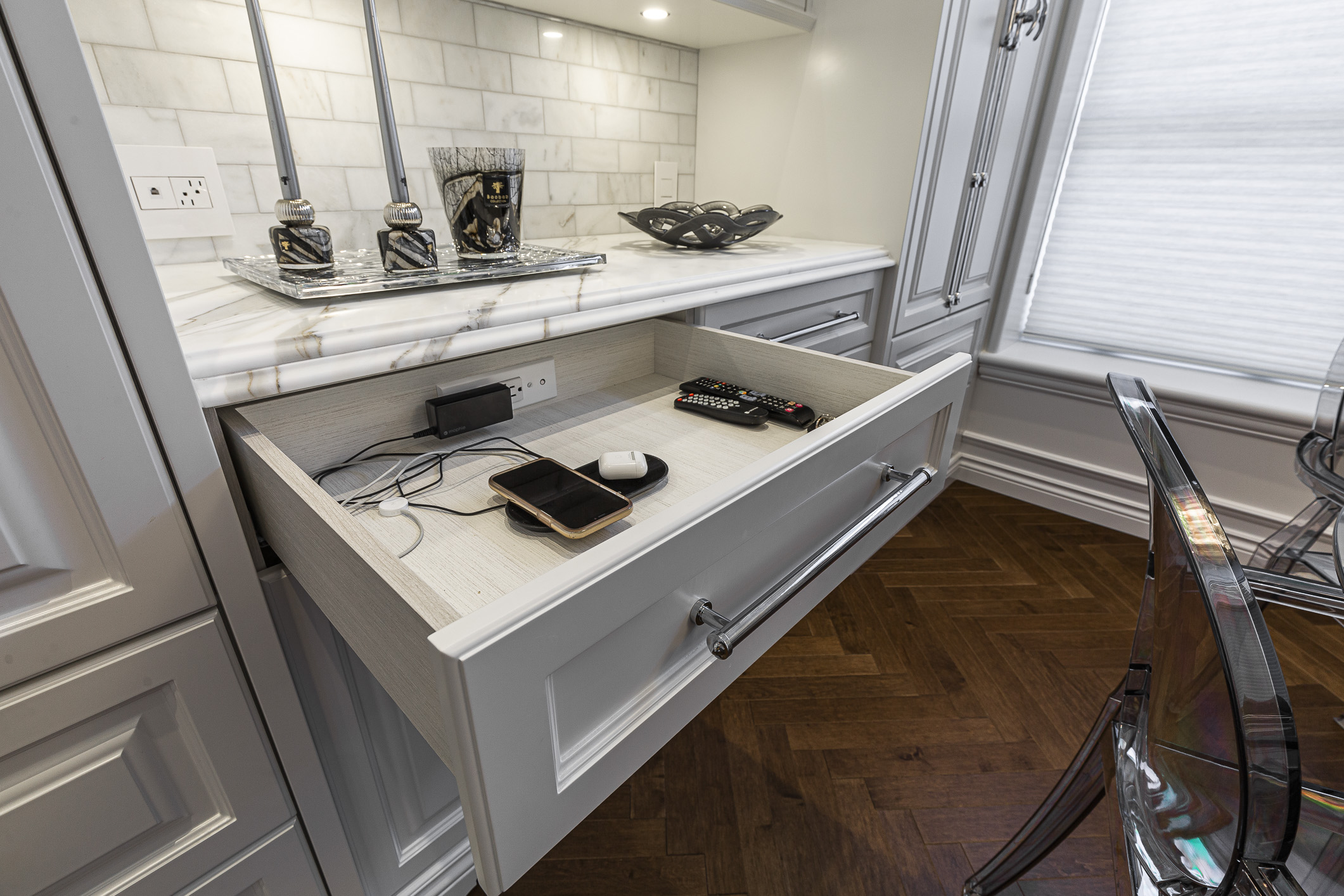 Sleek gray cabinetry and a chic marble countertop define this modern kitchen, blending style with organized tech functionality.