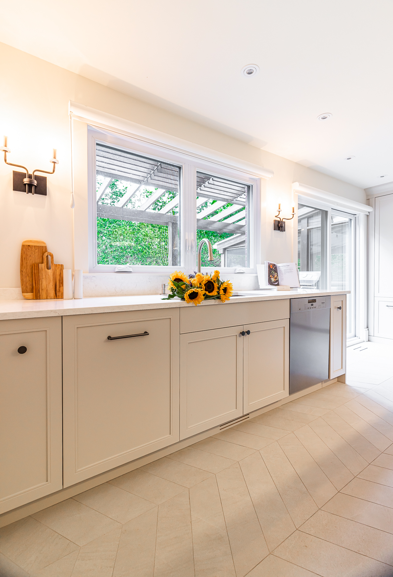 Inviting modern kitchen with sunflower centerpiece, sleek cabinetry, and abundant natural light.