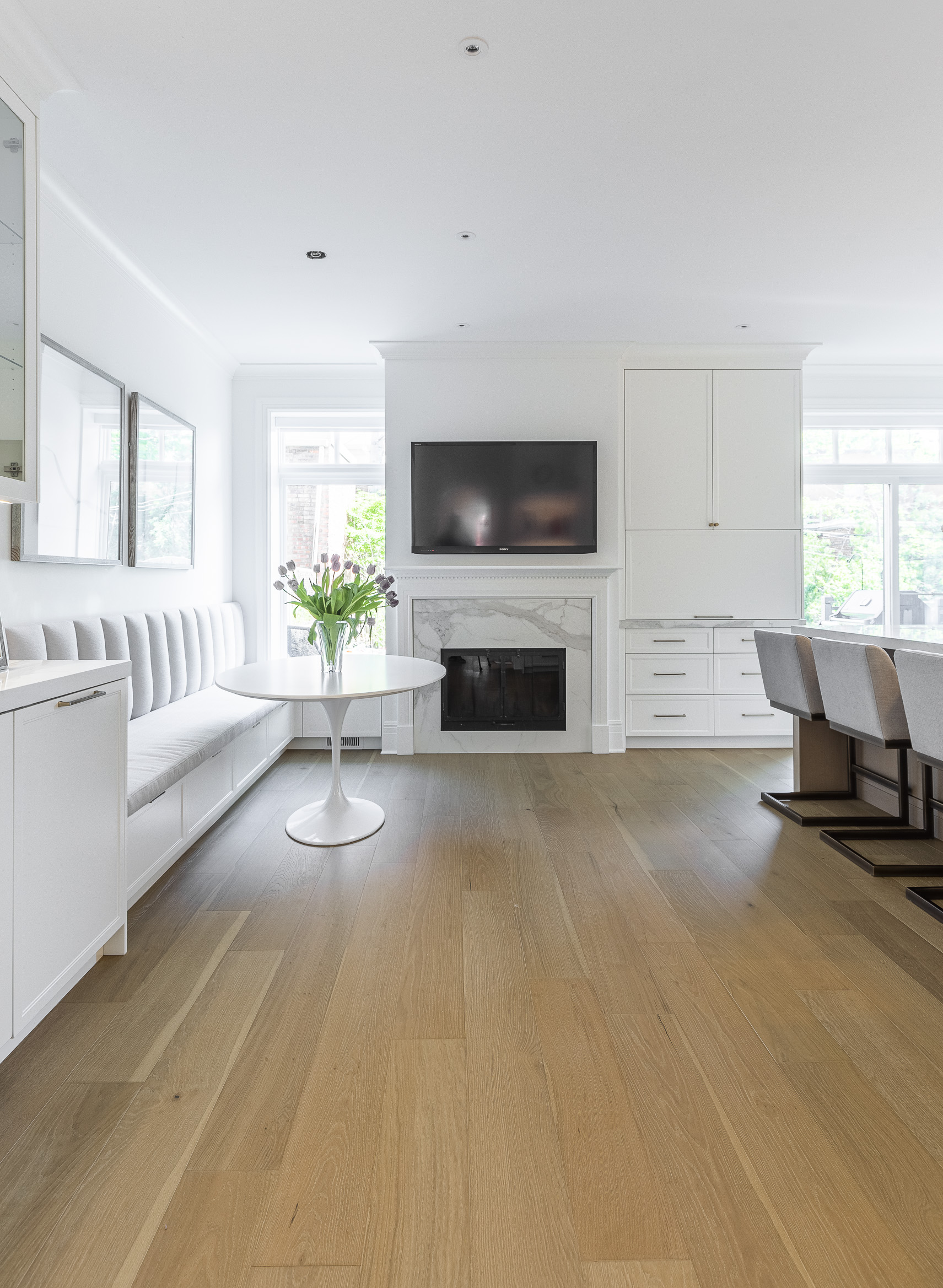 Discover a bright, modern living space featuring a sleek sectional sofa, glass table, and inviting fireplace, perfect for relaxation and gatherings.