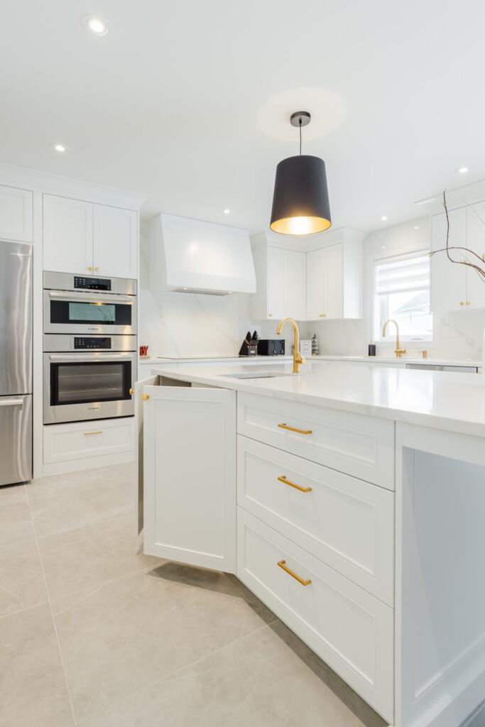 Bright modern kitchen with sleek white cabinetry, elegant gold accents, and stylish black lighting.