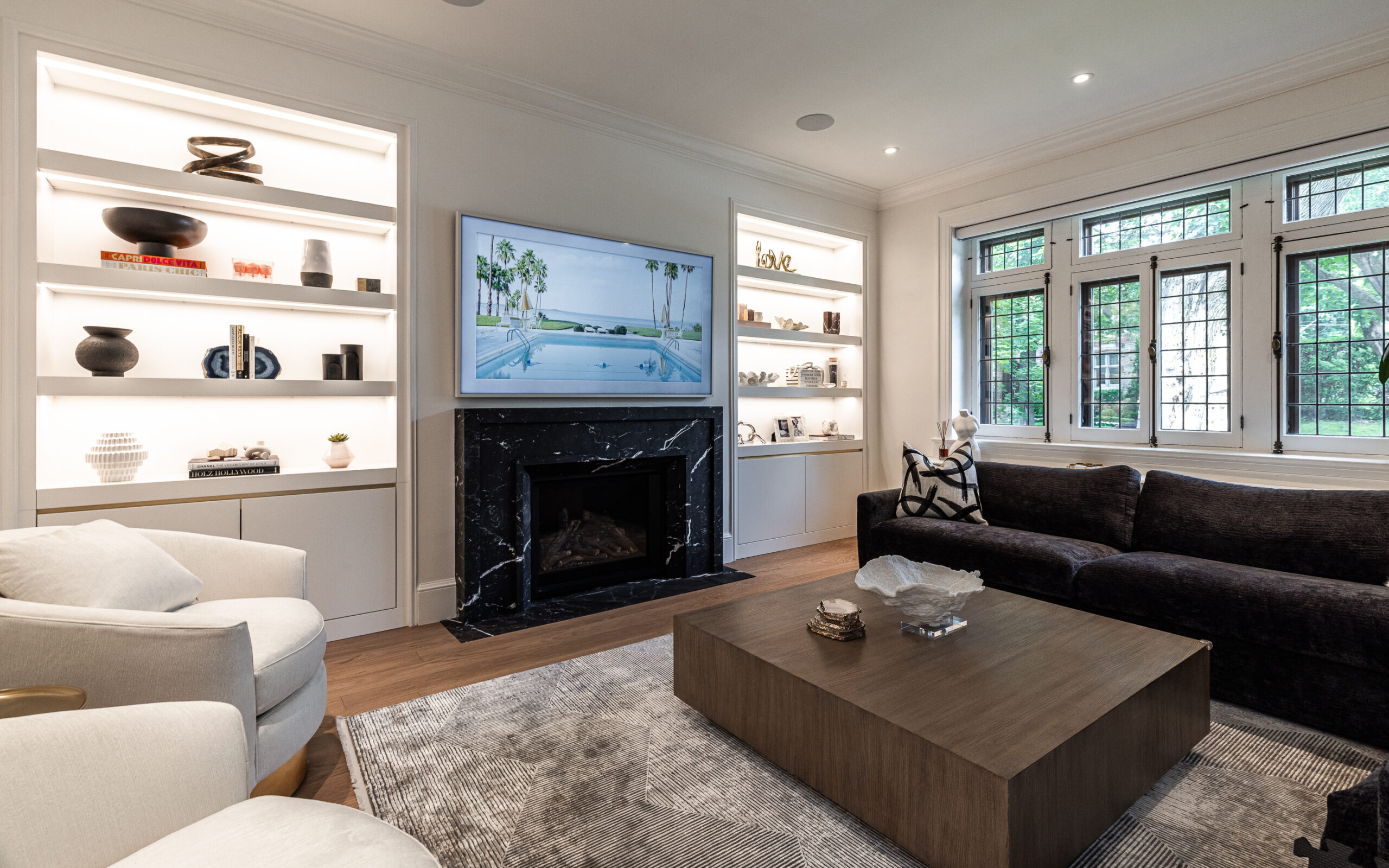 Modern minimalist living room featuring a beach-view TV, chic seating, and cozy natural light for a stylish retreat.