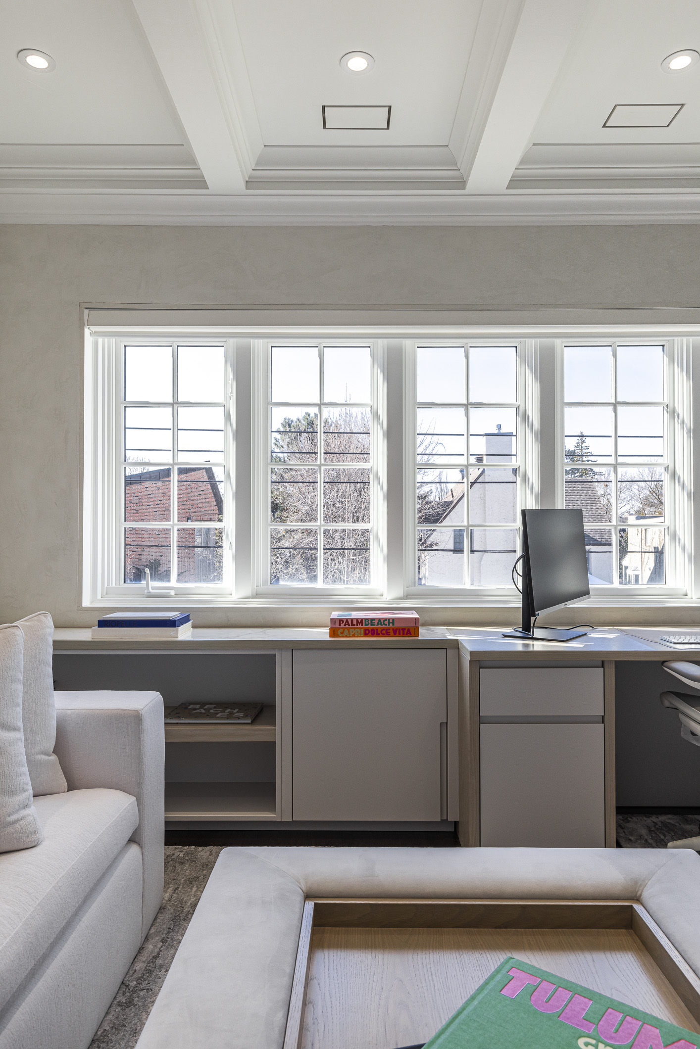 Bright and inviting modern office space featuring natural light, a cozy sofa, and an organized workspace for productivity.