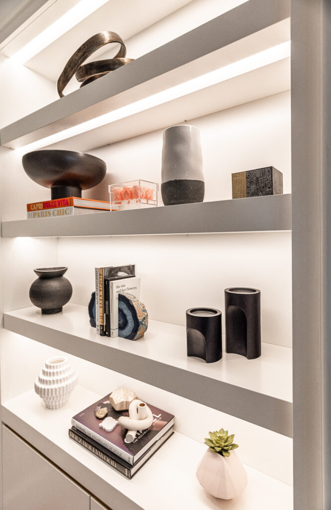 Stylish modern shelving with decorative objects, books, and warm lighting for a sophisticated look.