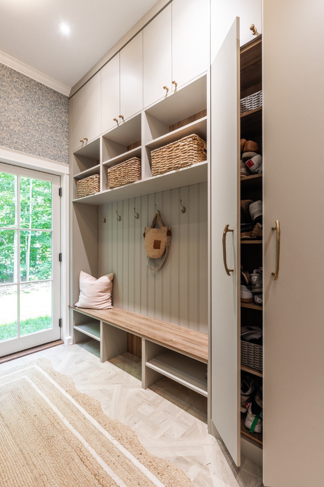 An elegant mudroom features stylish storage, a cozy bench, and bright natural light for an inviting entrance.