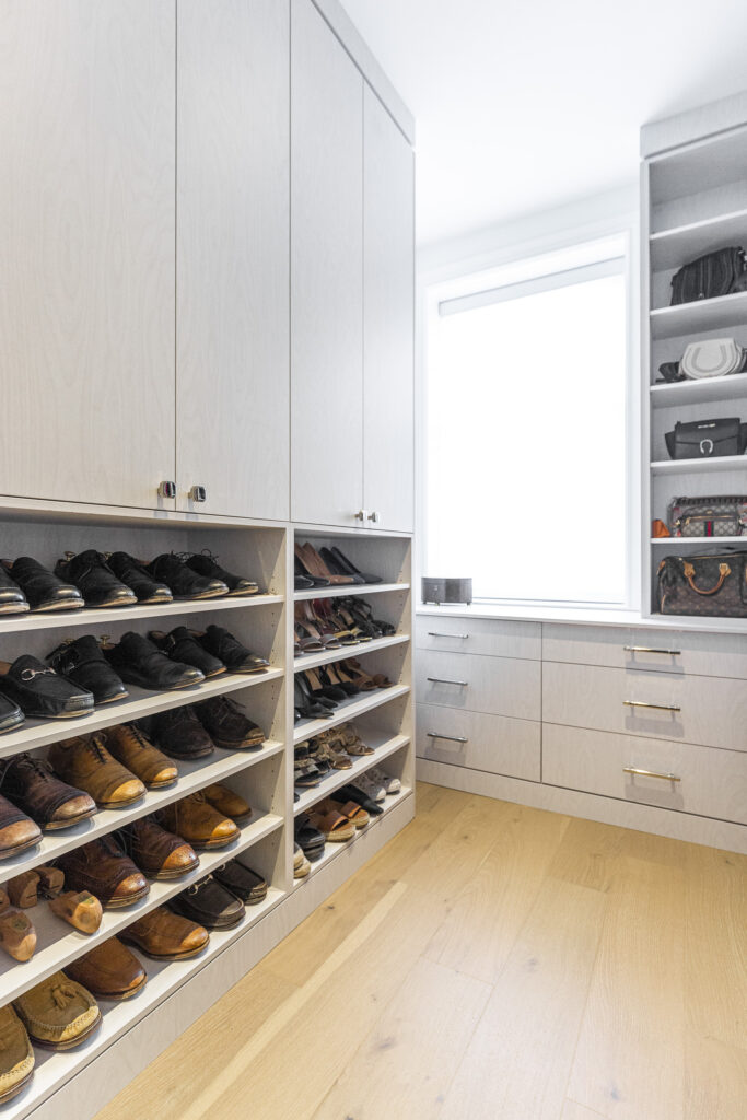 Modern shoe closet design with organized shelves, stylish cabinets, and bright natural light.