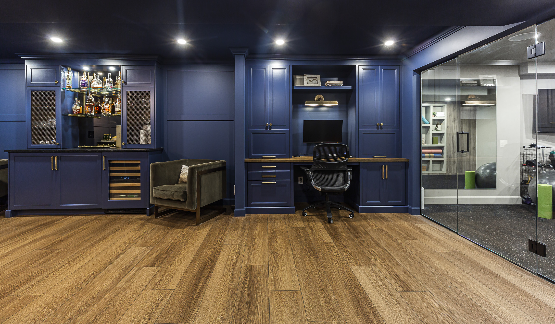 Discover a chic home bar and modern workspace designed for style, comfort, and productivity, featuring deep blue walls and luxurious accents.