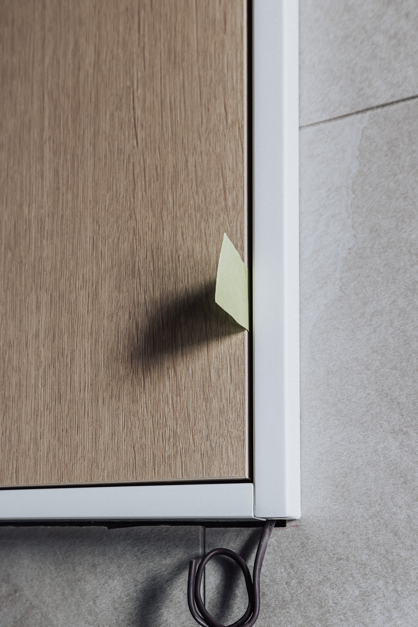A light brown wooden surface features a colorful sticky note, blending natural elegance with modern touches in a serene setting.