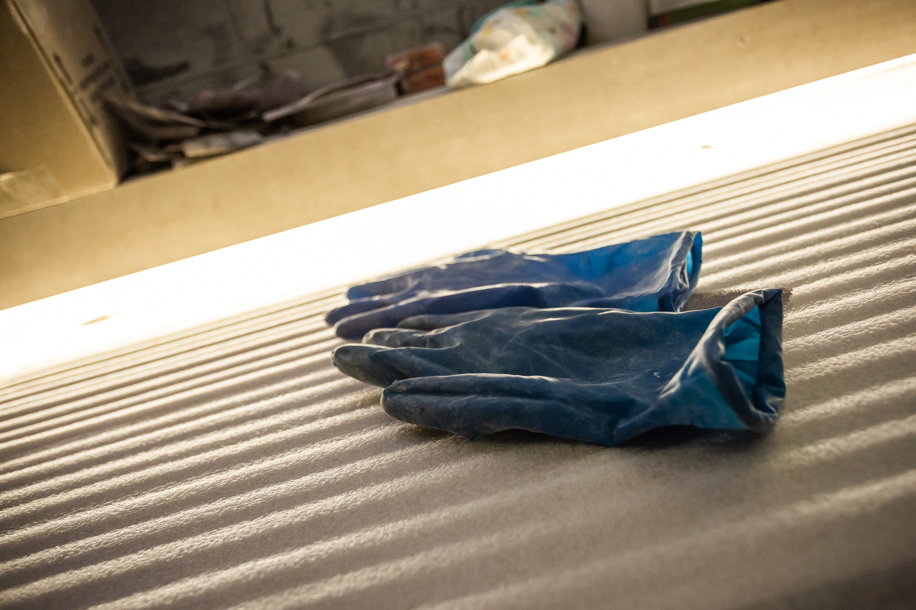 Bright blue gloves rest on a textured surface, emphasizing safety and hygiene in a workspace.