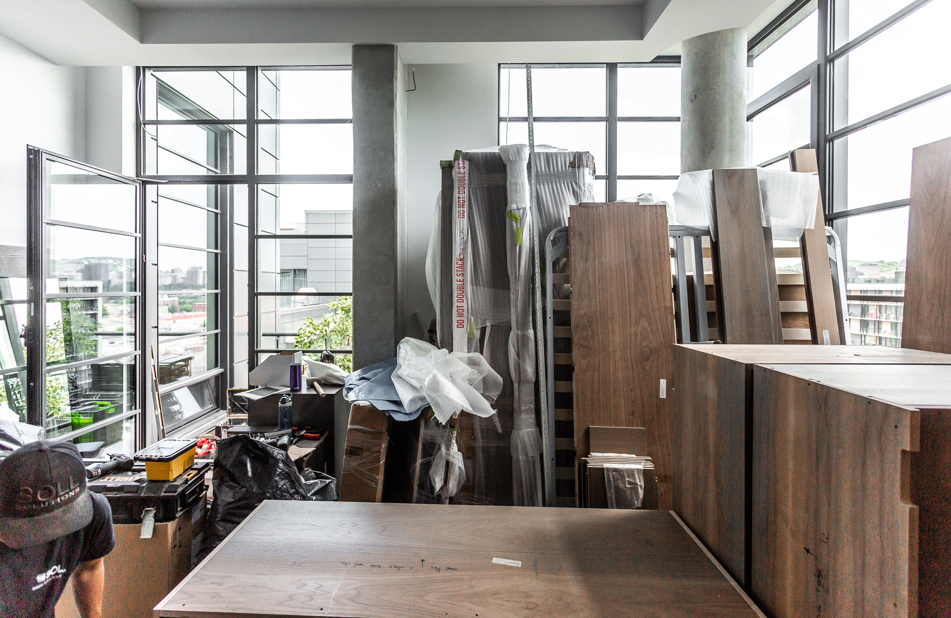 Spacious renovation area filled with building materials and furniture, seamlessly blending modern design with vibrant outdoor greenery.