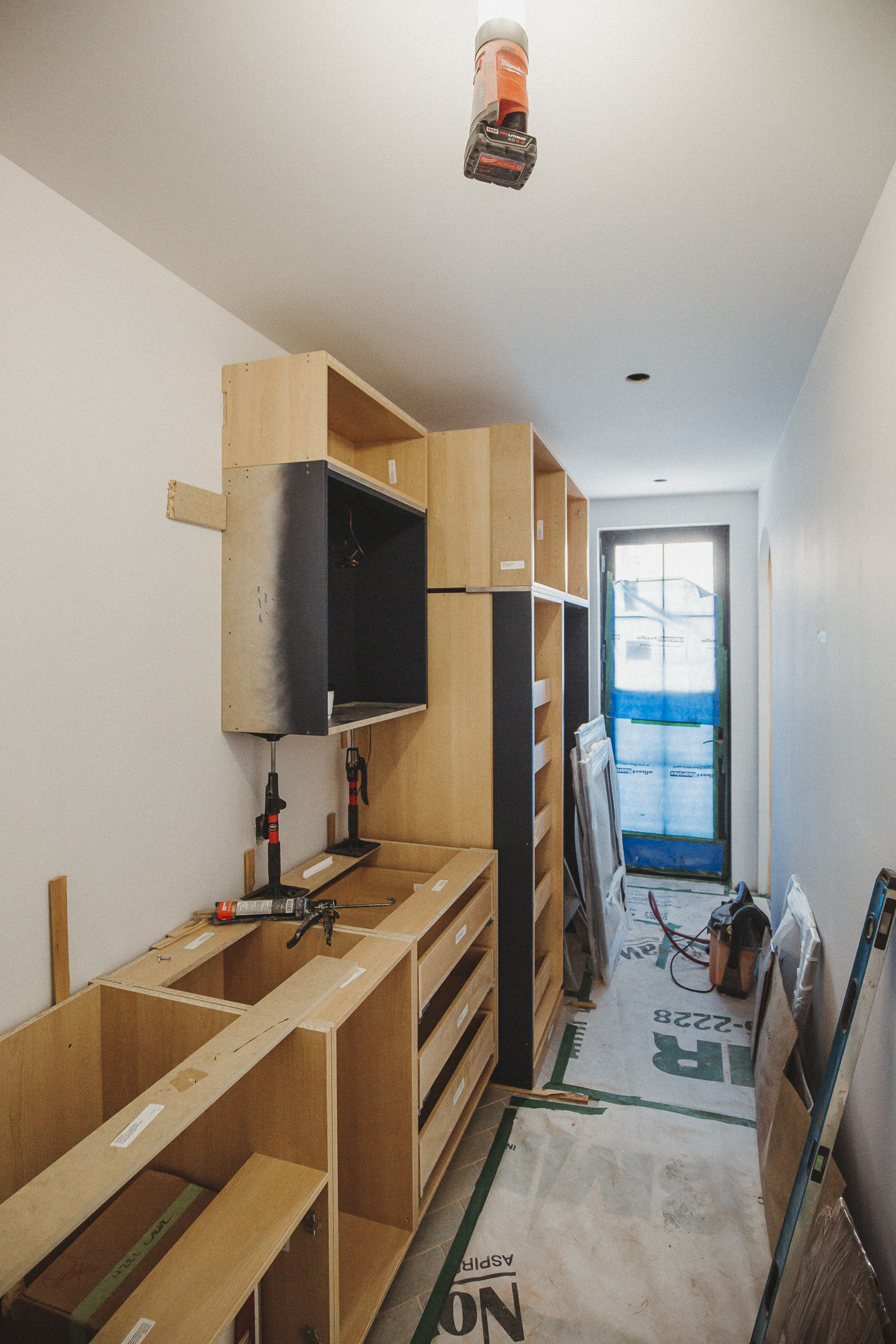 A modern renovation in progress, featuring bright cabinetry, natural light, and an organized workspace ready for finishing touches.